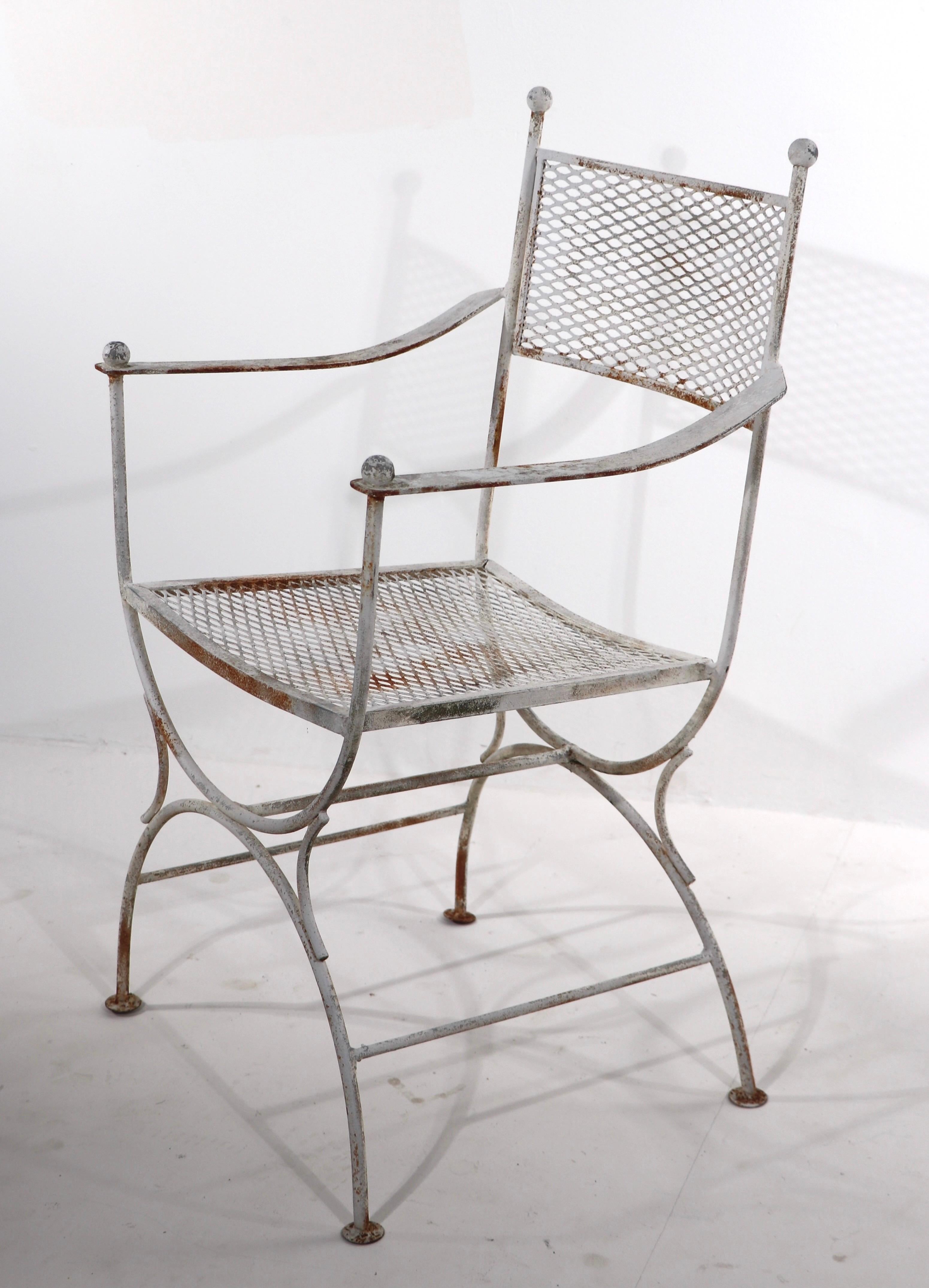 Chic pair of wrought iron and metal mesh garden, patio, armchairs attributed to Salterini. Both chairs are structurally sound, and sturdy, both show cosmetic wear to the finish, normal and consistent with age. Usable as is, or we offer custom powder