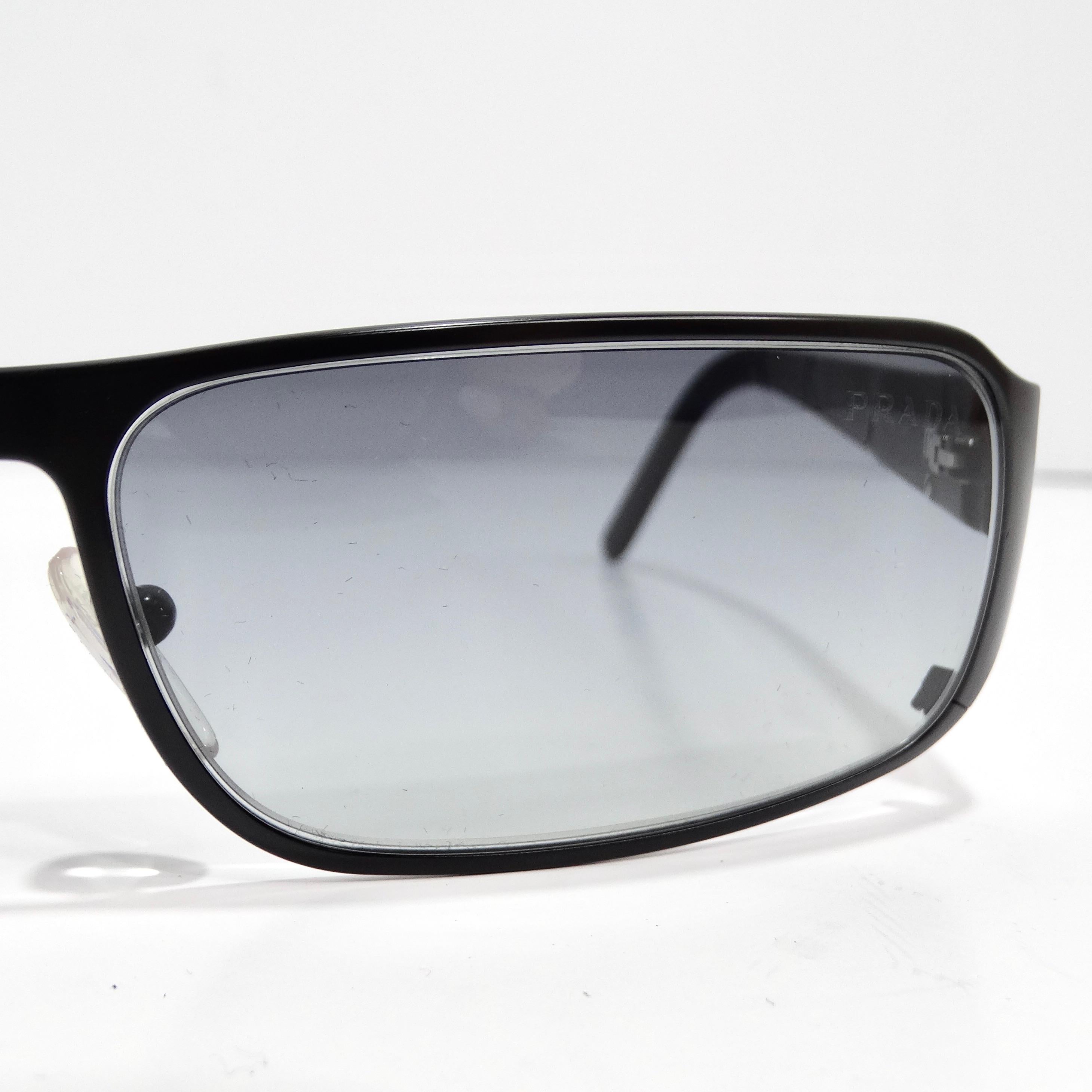 Entrez dans l'élégance intemporelle des lunettes de soleil Prada 1990 à monture rectangulaire noire, un accessoire classique qui allie sans effort sophistication et style durable. Ces lunettes de soleil sont dotées de fins bords noirs, de branches