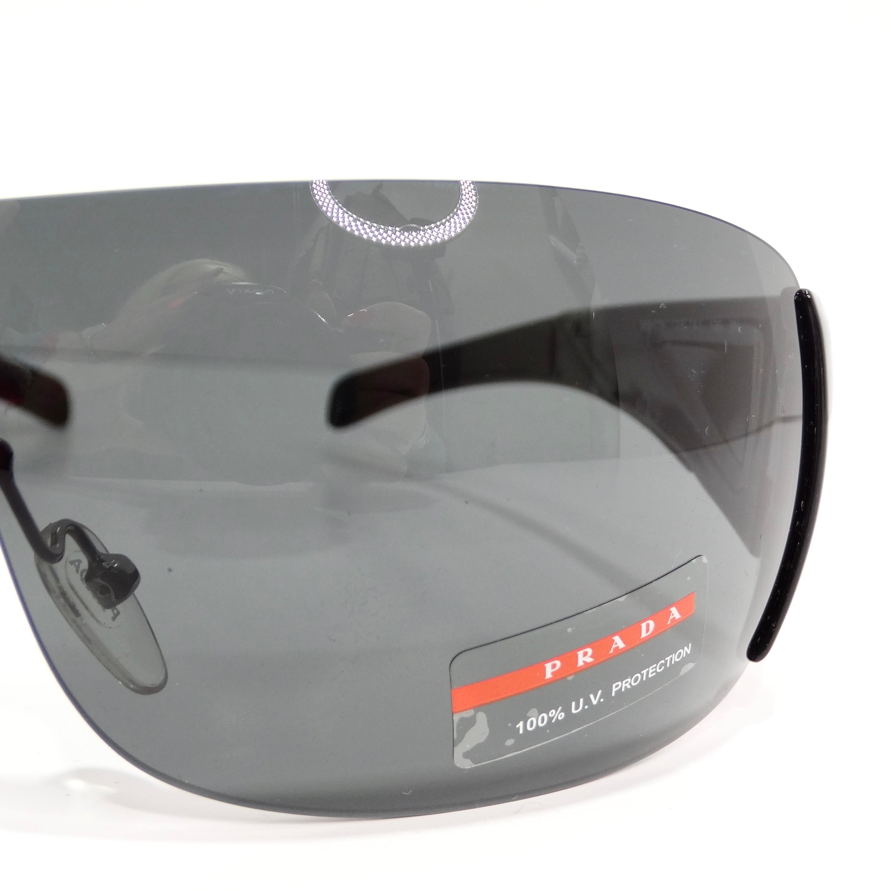 Embrace timeless sophistication with the Prada 1990s Black Shield Style Sunglasses, a classic shield design that effortlessly combines chic style with enduring elegance. These sunglasses feature a shield-style silhouette with black arms adorned with