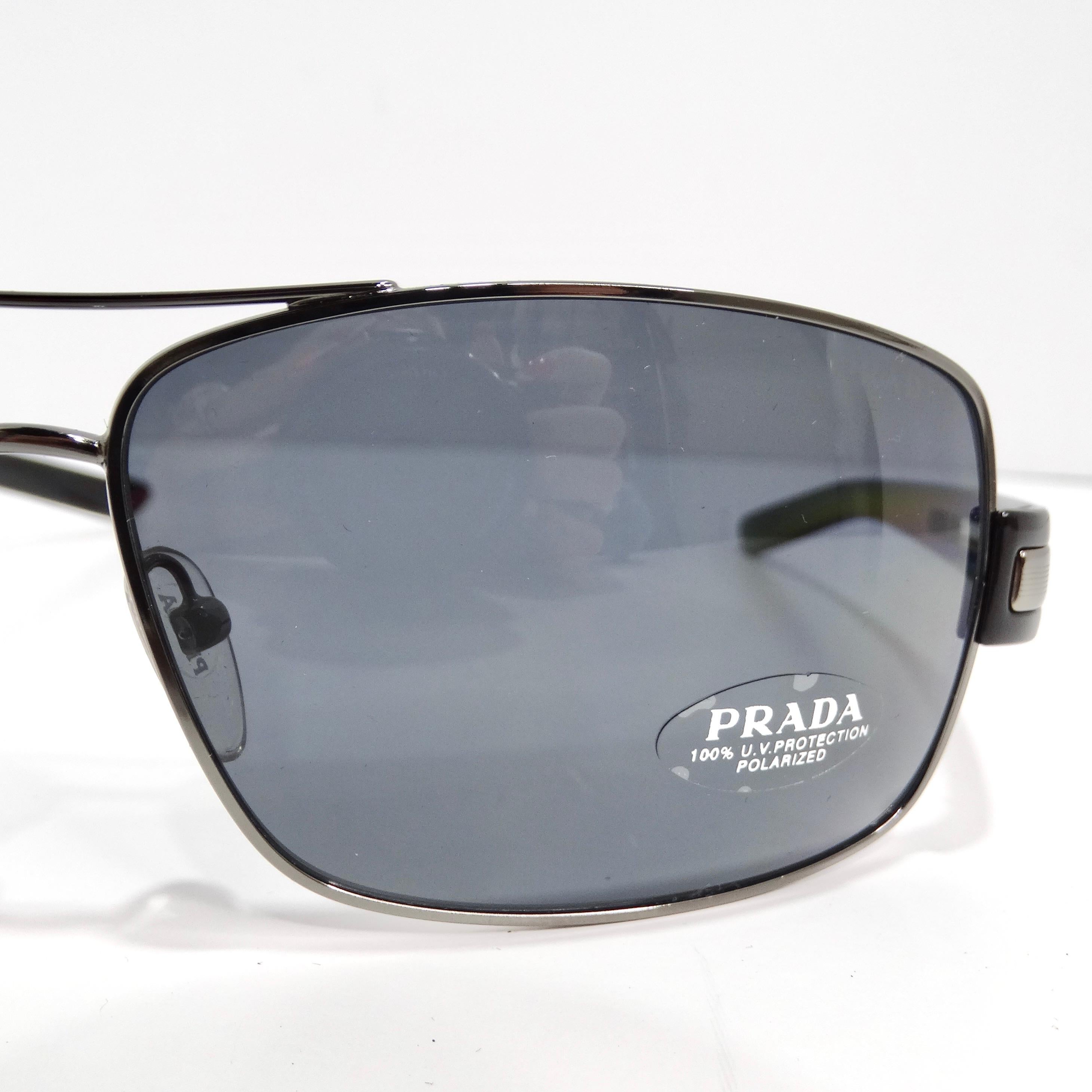 Step into timeless sophistication with the Prada 1990s Black Silver Tone Aviator Sunglasses, a classic aviator style that effortlessly combines elegance with enduring style. These sunglasses feature thin silver-tone rims, complemented by black arms