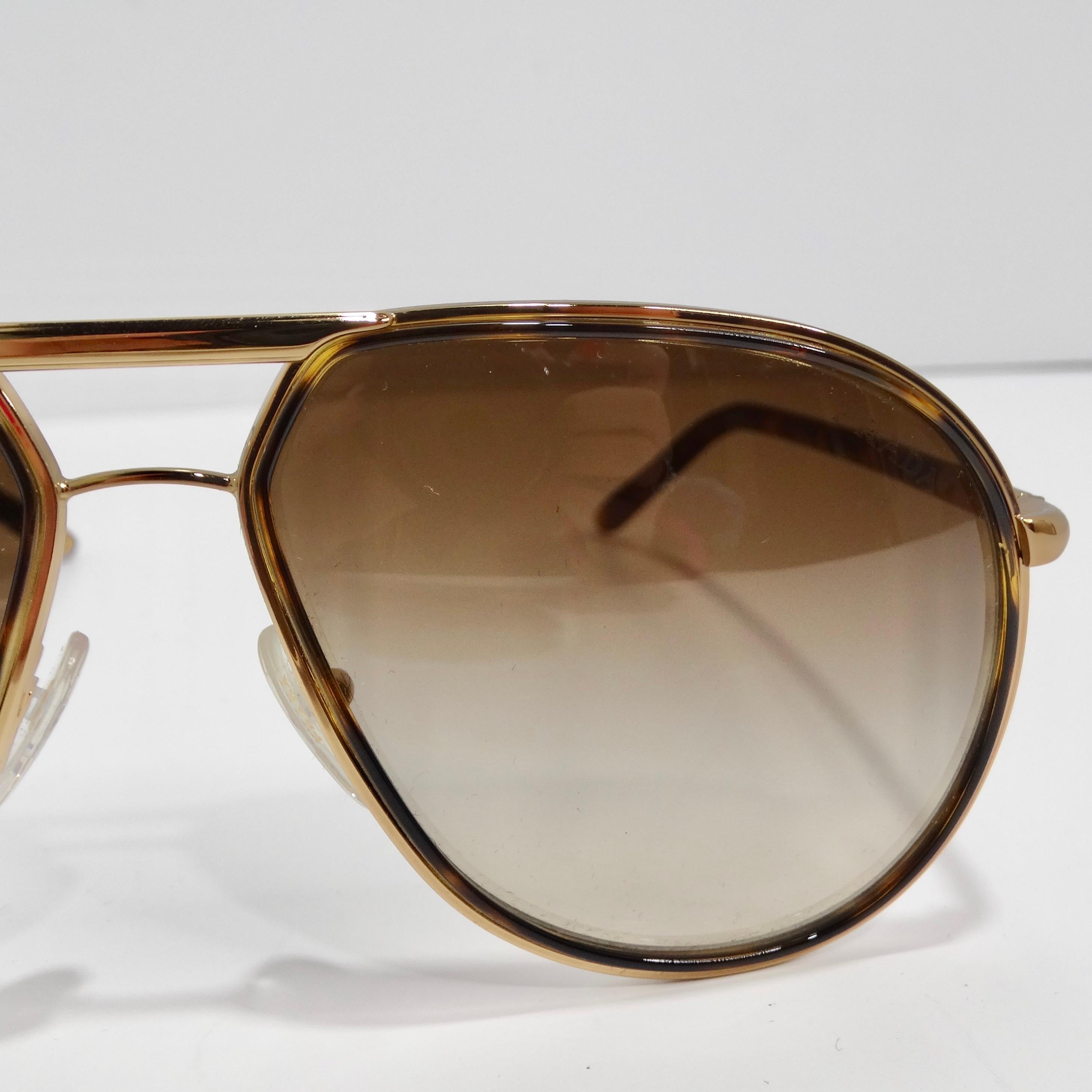 Elevate your style with the Prada 1990s Gold Tone Tortoise Shell Aviator Sunglasses, a classic aviator design that exudes timeless chic and sophistication. These sunglasses feature thin gold-tone rims, complemented by brown tortoise shell arms