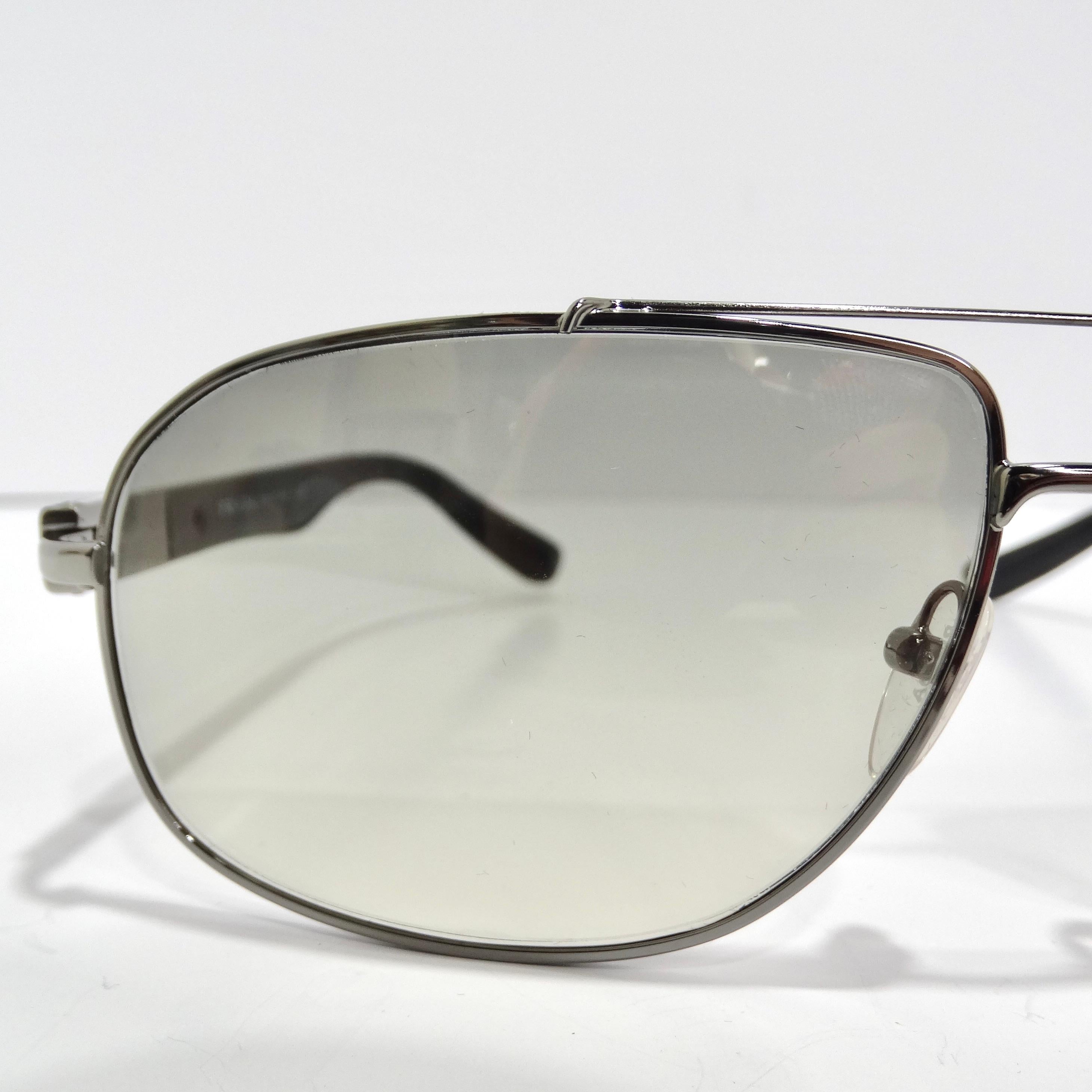 Step into retro elegance with the Prada 1990s Silver Tone Aviator Sunglasses, a timeless accessory that perfectly blends classic style and contemporary flair. These sunglasses boast the iconic aviator design with thin silver-tone rims, paired with