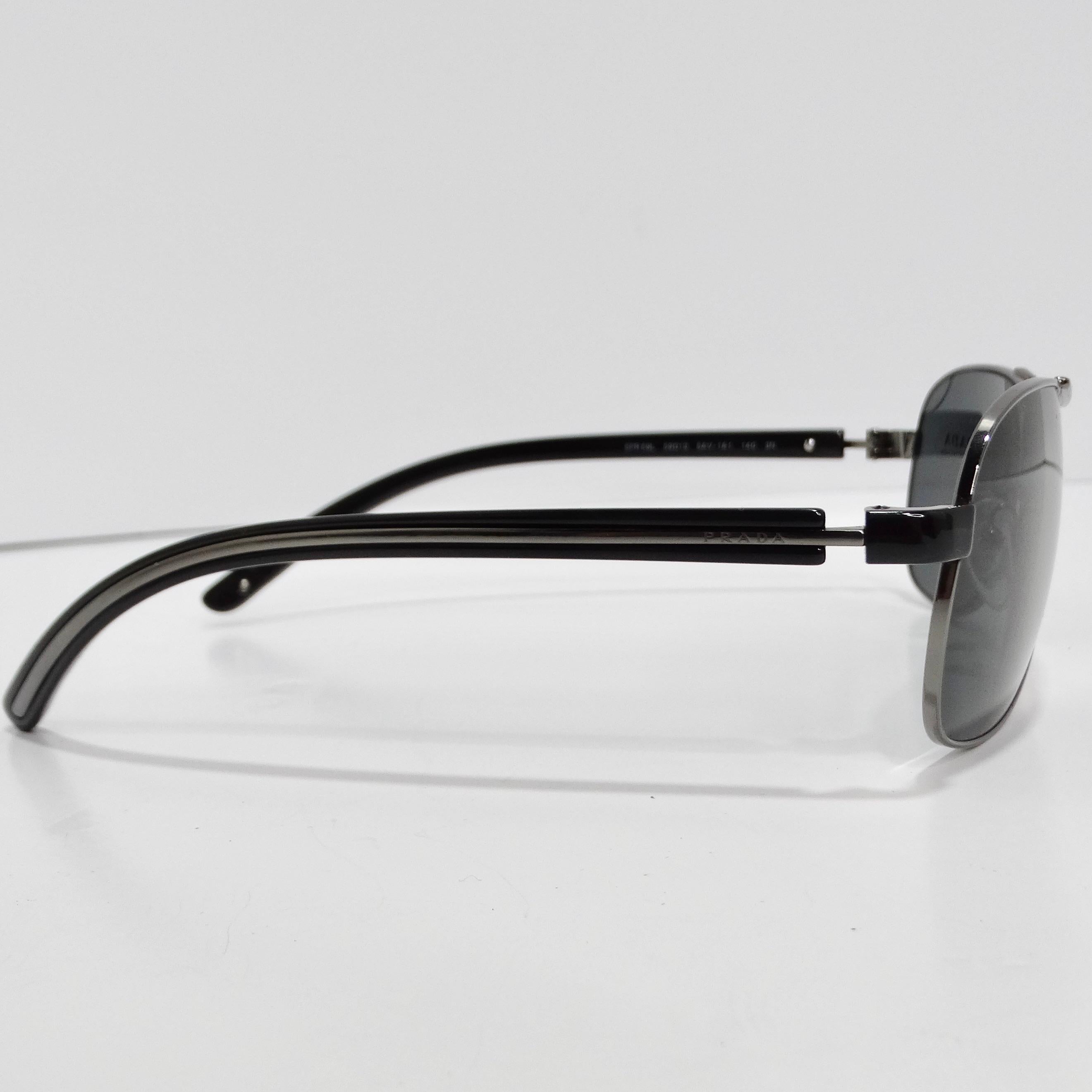 Mit der Prada 1990s Silver Tone Aviator Sonnenbrille, einem zeitlosen Stück, das klassische Raffinesse ausstrahlt, verleihen Sie Ihren Brillen eine neue Dimension. Diese Sonnenbrille zeigt den ikonischen Pilotenstil mit dünnen, silberfarbenen