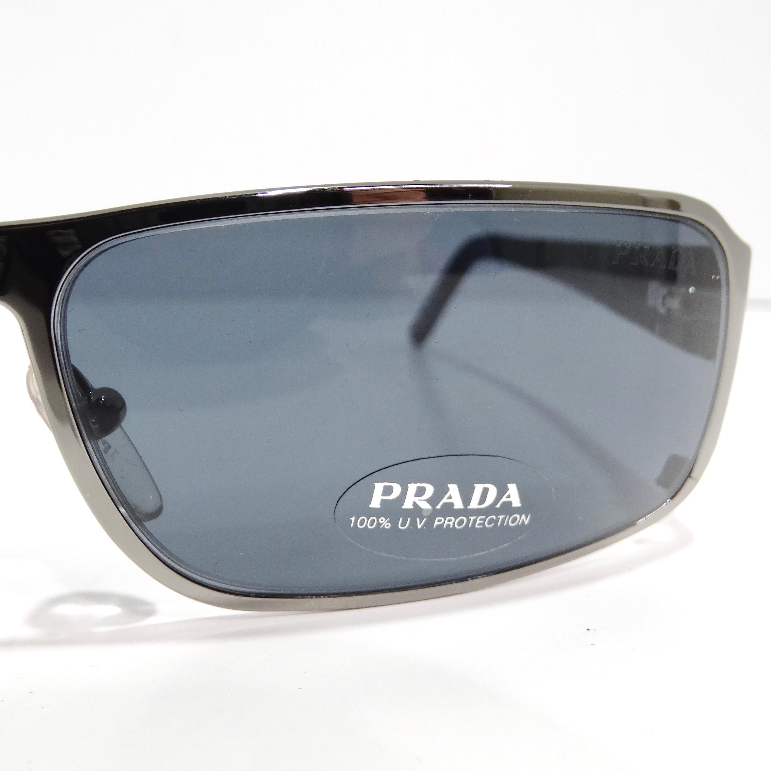 Entrez dans l'allure des années 1990 avec les lunettes de soleil Prada 1990 à monture rectangulaire argentée, un accessoire classique et intemporel qui respire la sophistication. Ces lunettes de soleil présentent une monture rectangulaire aux fins