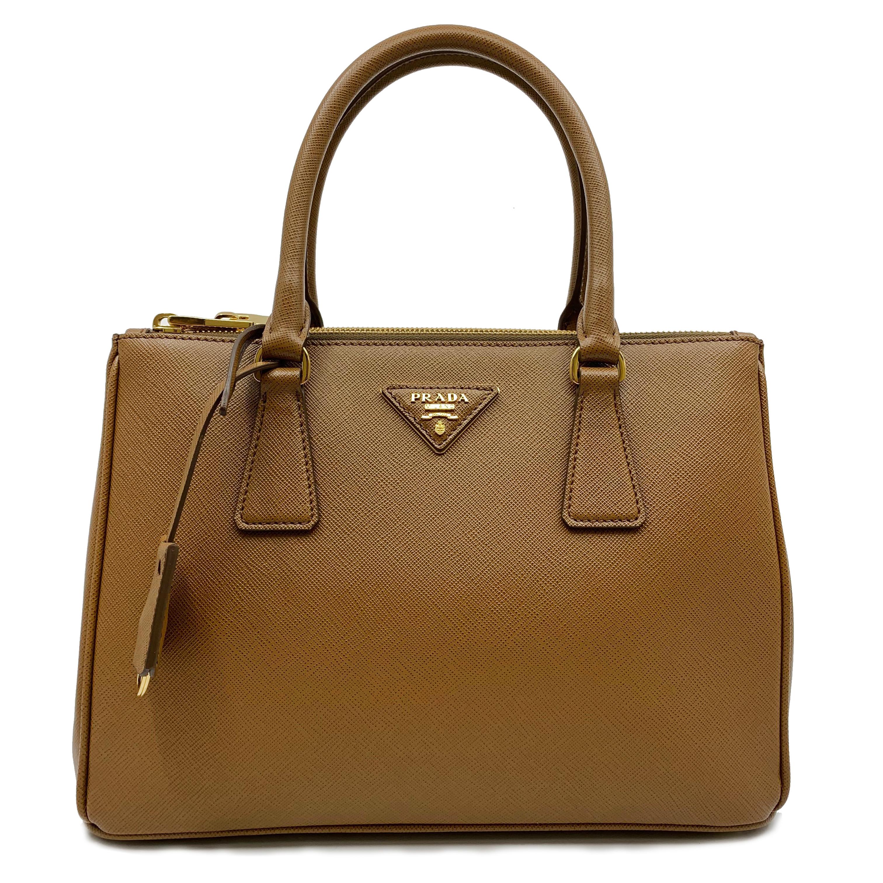 Prada's Saffiano luxe tote is a perfectly prim addition to your accessories edit. Crafted from textured brown calf leather, this design is finished with dainty top handles and golden hardware. Comes without Dust Bag. Authenticity Card is included.