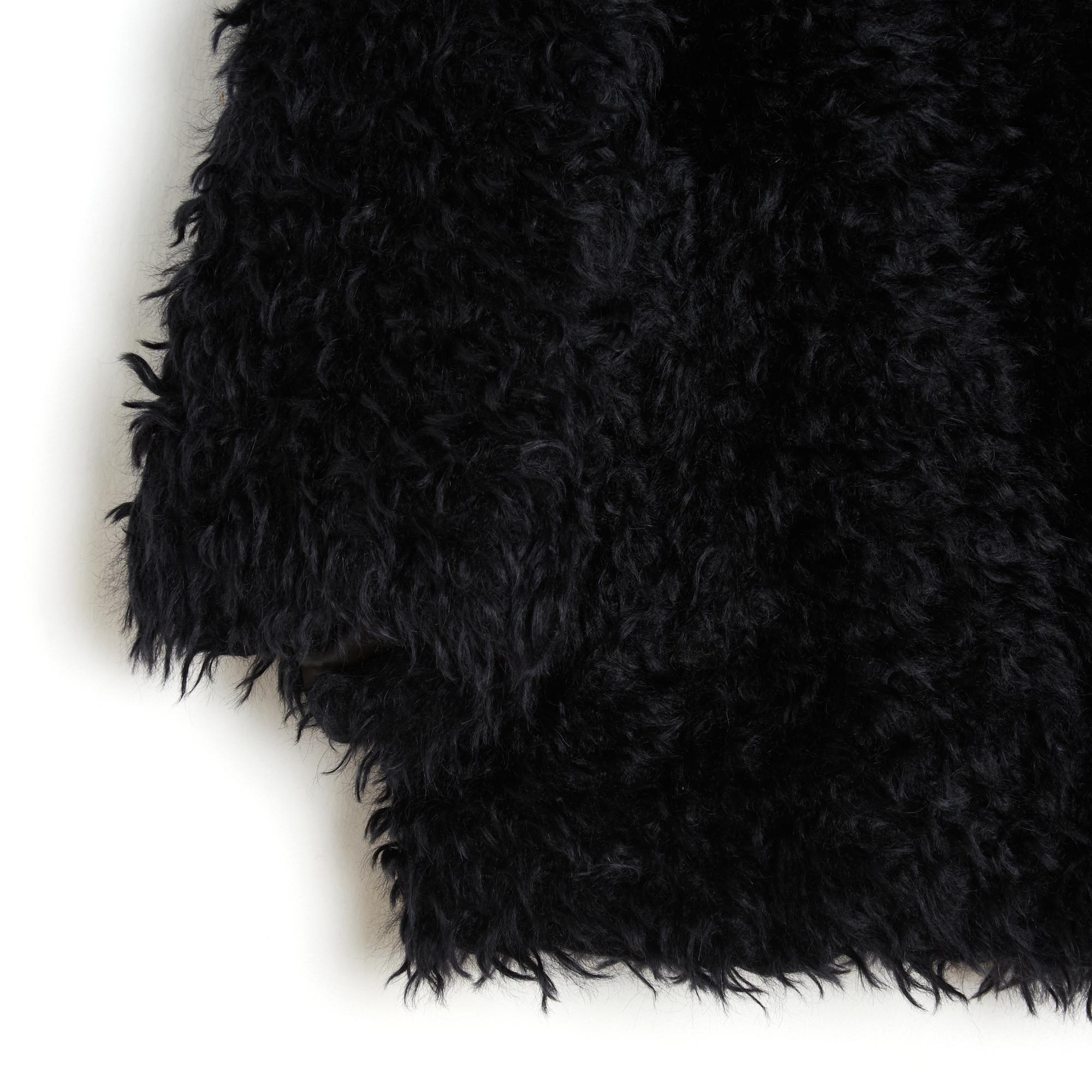 Prada jacket from the AH 2007 collection in black faux fur, round collar closed by 3 large black painted metal snaps, 2/3 sleeves closed by a large matching snap, opening under the arm (!?), 2 slit pockets on the sides, black satin canvas lining.
