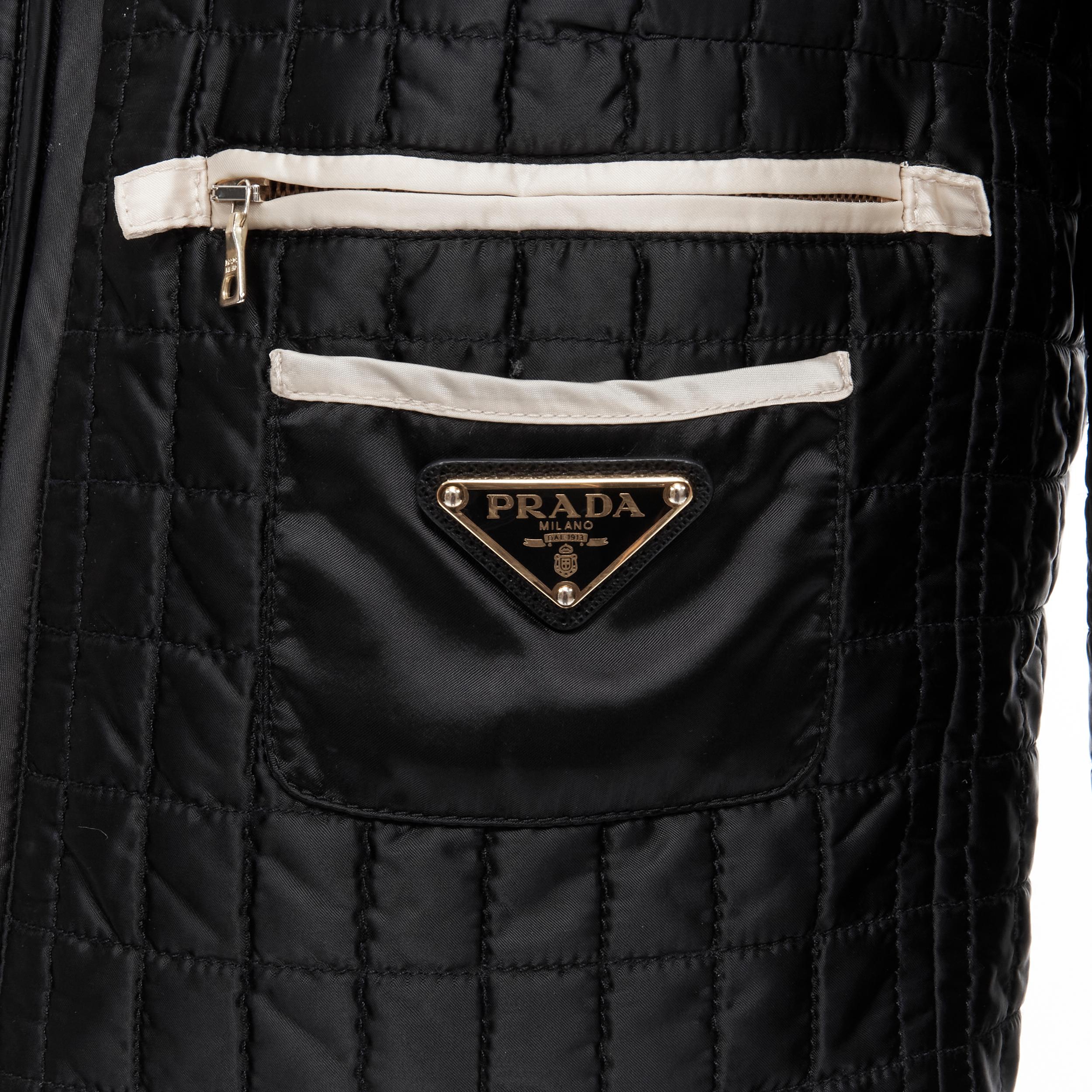 PRADA 2010 black quilted nylon logo seal pocket collarless shell jacket IT38 XS 
Reference: TGAS/B01883 
Brand: Prada 
Designer: Miuccia Prada 
Material: Nylon 
Color: Black 
Pattern: Solid 
Closure: Zip 
Extra Detail: Zip and patch pocket with gold