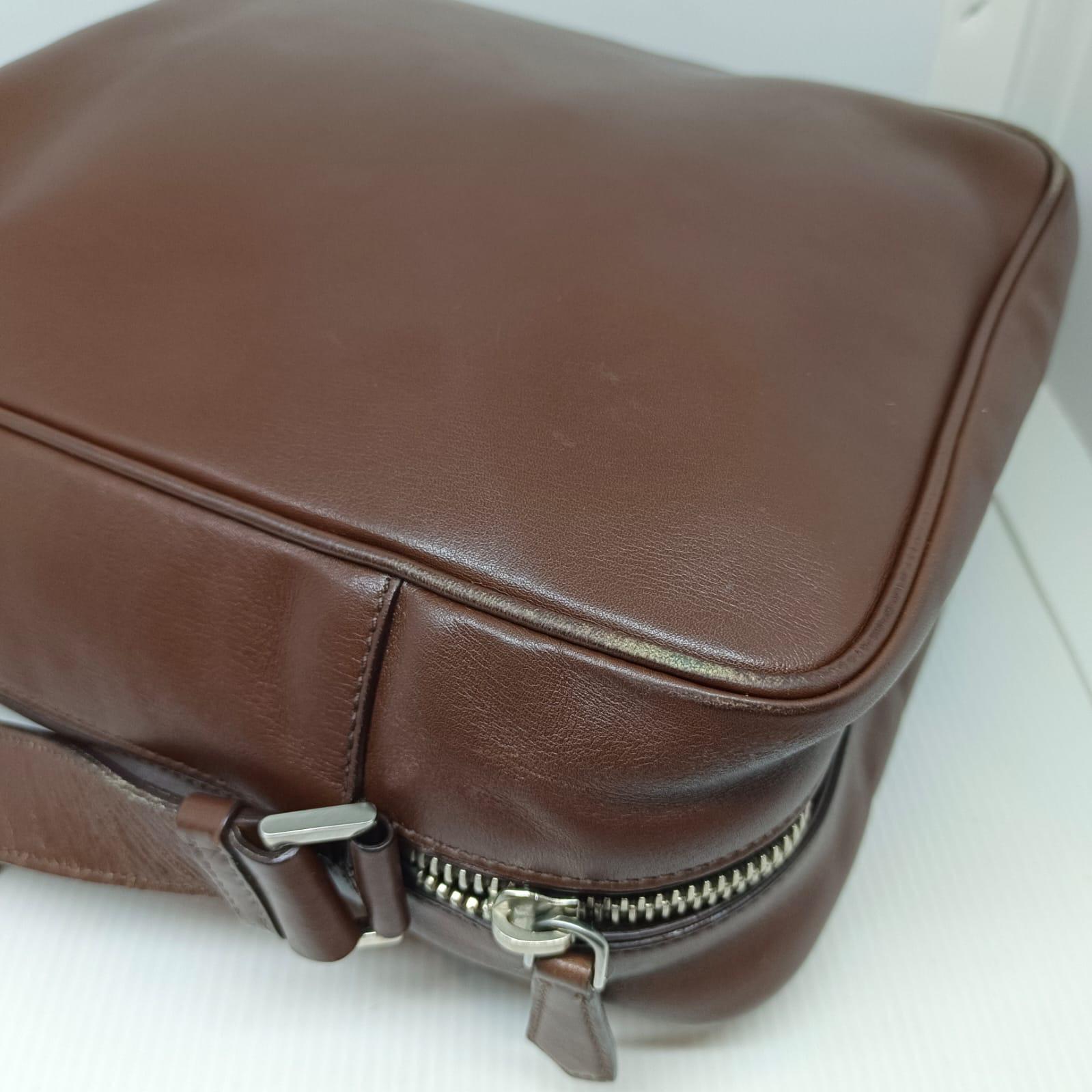 Casual crossbody bag for men in dark brown leather. Visible rubbing and scuffs on the leather surface, especially the corners. Overall still in good worn condition. Comes with its authenticity card only.