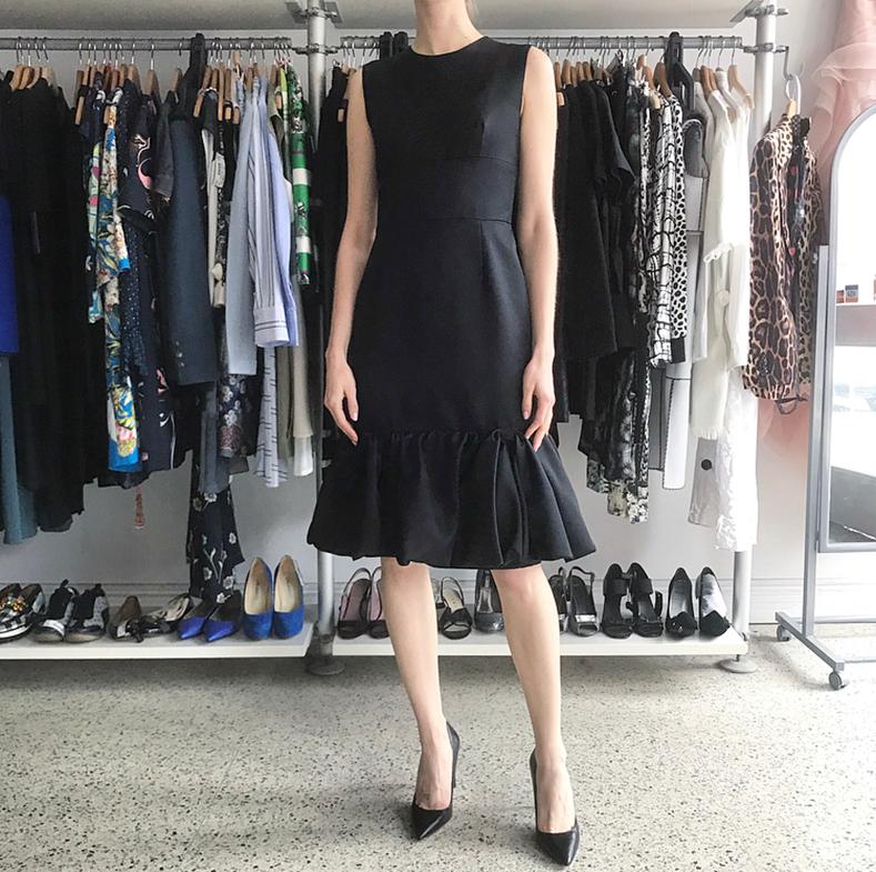 Prada Fall 2017 Black Sleeveless Cocktail Dress with Ruffle Hem.  1960's inspired design similar to Audrey Hepburn's Breakfast at Tiffany's dress. Sleeveless design with invisible centre back zipper, fitted silhouette, waistband inset, flared hem. 