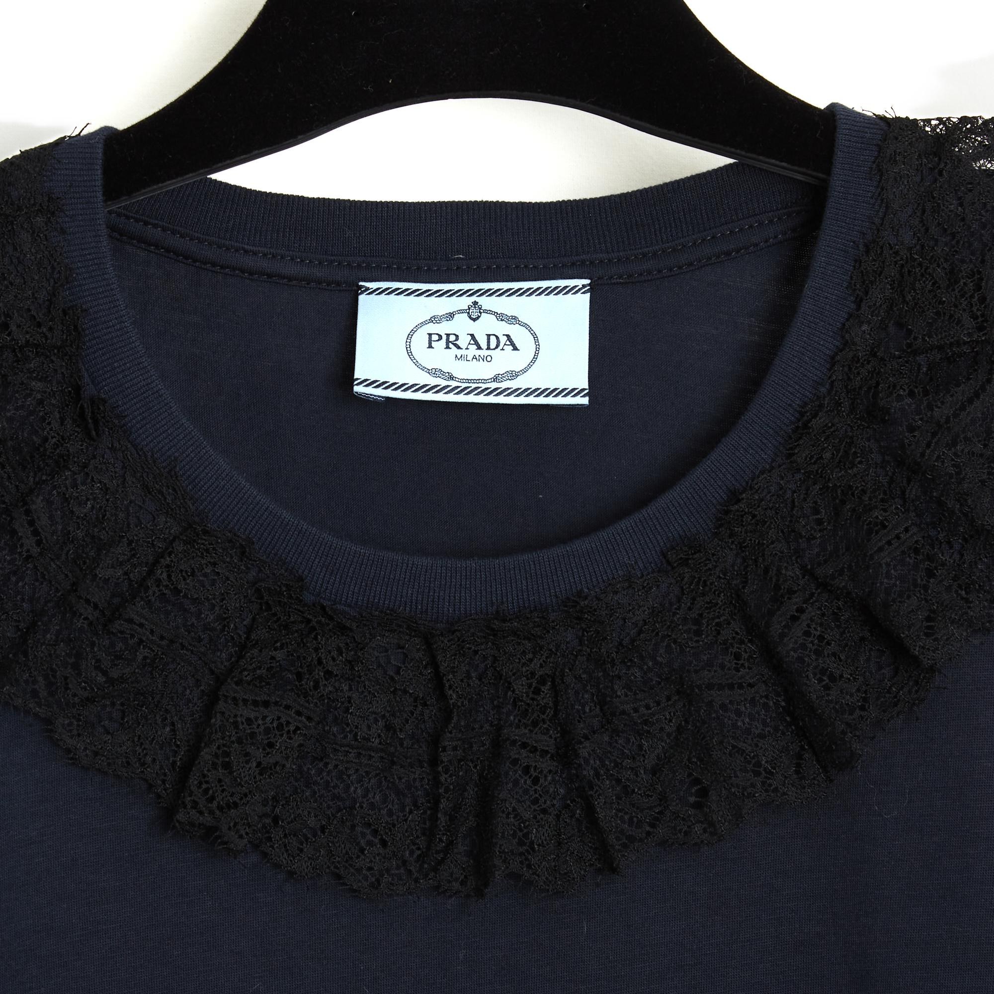 Top Prada 2015 t-shirt in soft navy blue cotton jersey, round neck decorated with a black lace ruffle, short sleeves. Size L or 40FR or UK12 and US10: shoulders 44 cm, chest 50 cm; length 68 cm, sleeves 20 cm. The top is in excellent condition and