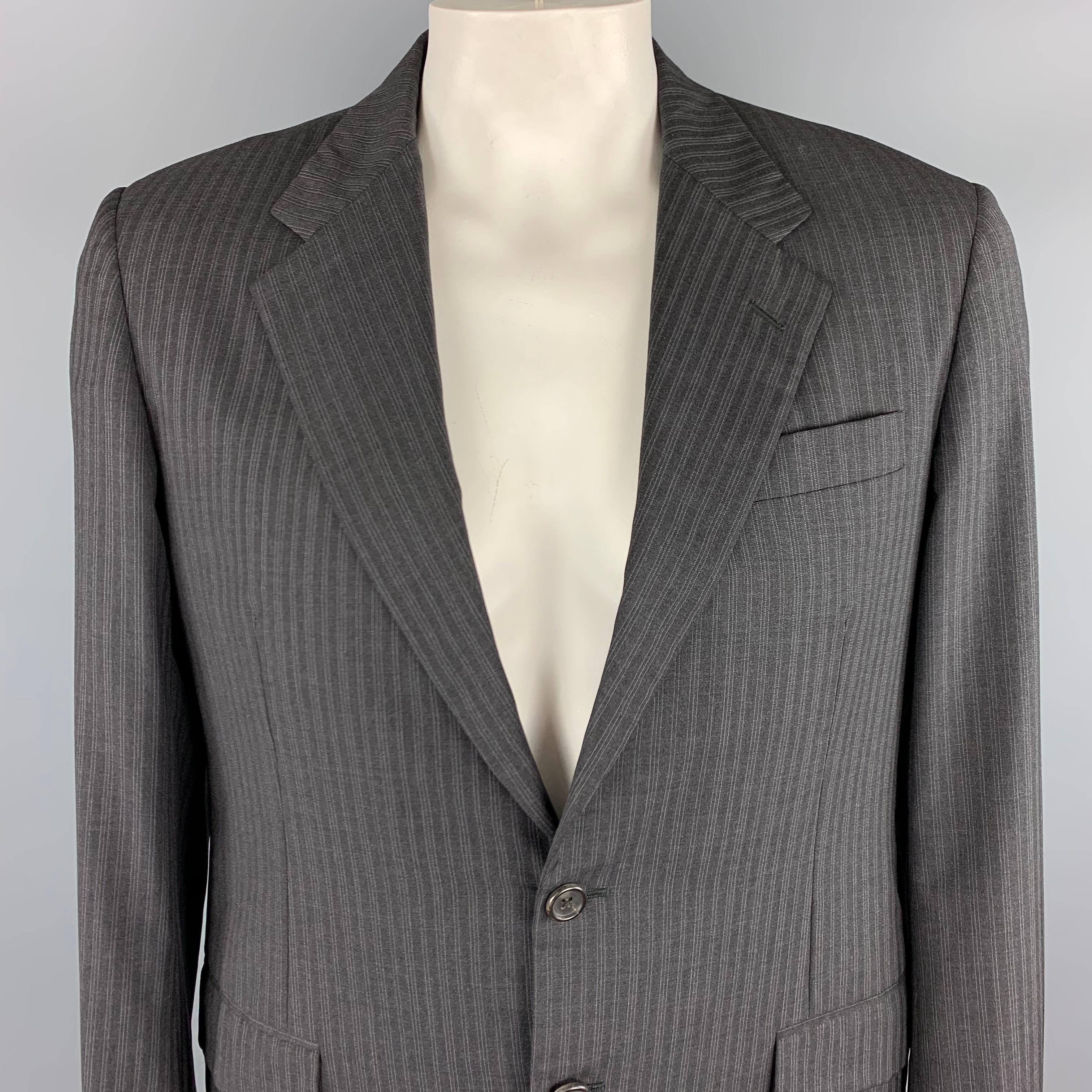 PRADA Sport Coat comes in a charcoal tone in a striped wool material, with a notch lapel, slit and flap pockets, two buttons at closure, single breasted, double vent at back and buttoned cuffs. Made in Italy.
 
Excellent Pre-Owned Condition.
Marked: