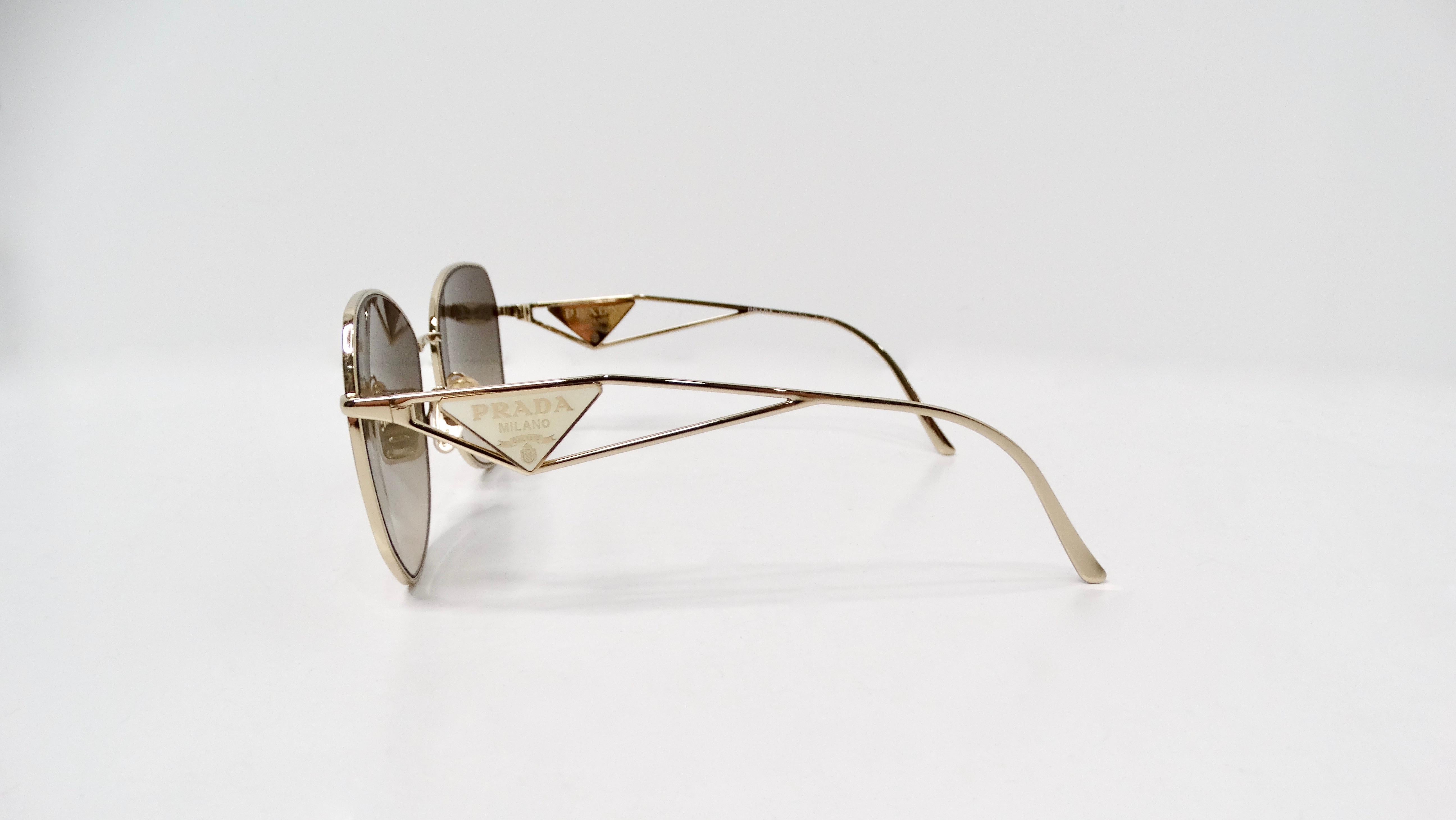 The Prada 57Y Gold-Tone Metal Frame Logo Aviator Sunglasses are the epitome of sophistication and timeless style. Featuring a sleek gold-tone metal frame, these luxurious aviators exude an air of elegance that complements any ensemble. The sides of