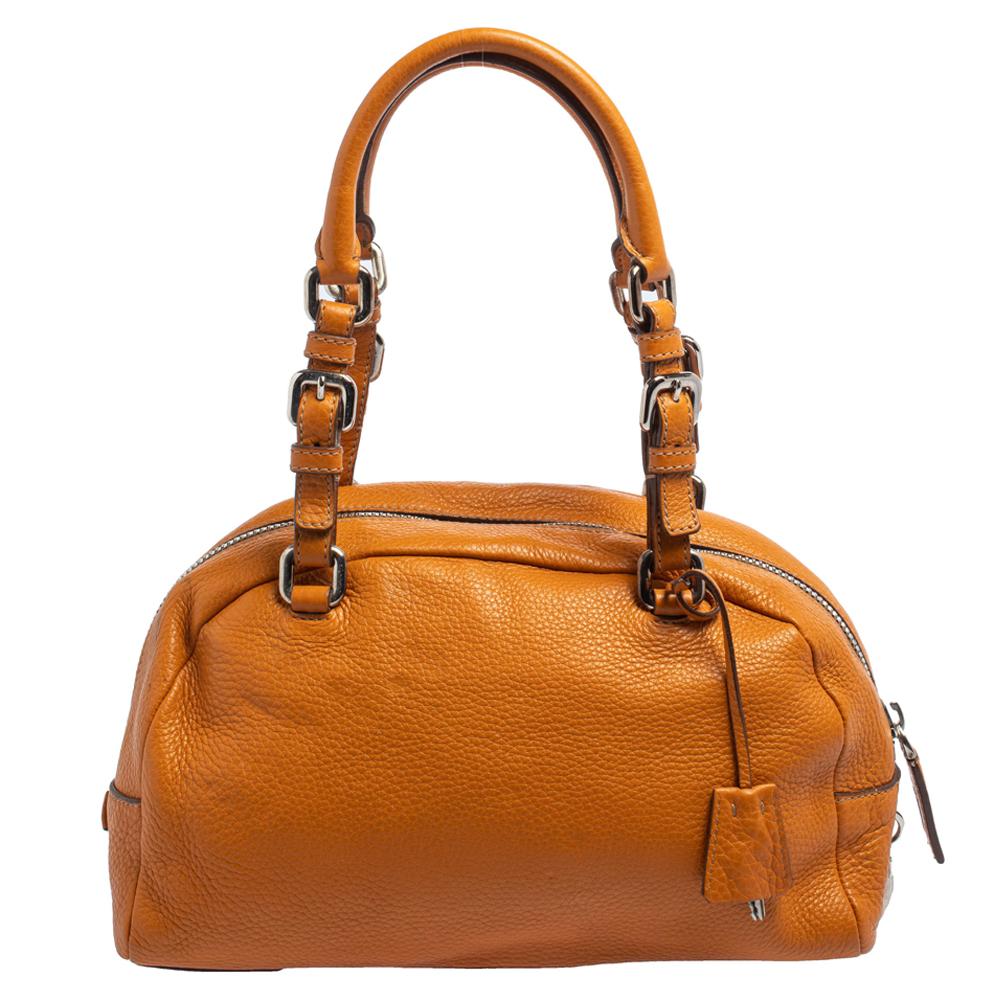 This Prada satchel will make a splendid addition to your closet. Crafted from Vitello Daino leather and flaunting the brand logo embossed on the front, it comes with dual handles and silver-tone hardware. It opens to a nylon-lined interior that is
