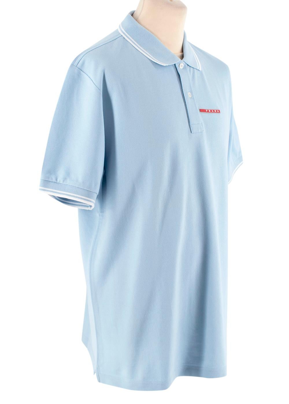 Prada Baby Blue Short Sleeve Polo Shirt
 

 - Baby blue cotton short sleeve polo shirt
 - Double white colour trim detail to the pointed collar, and cuffs
 - Signature Prada red bar logo on the chest
 - Two button closure
 

 Materials 
 100% Cotton