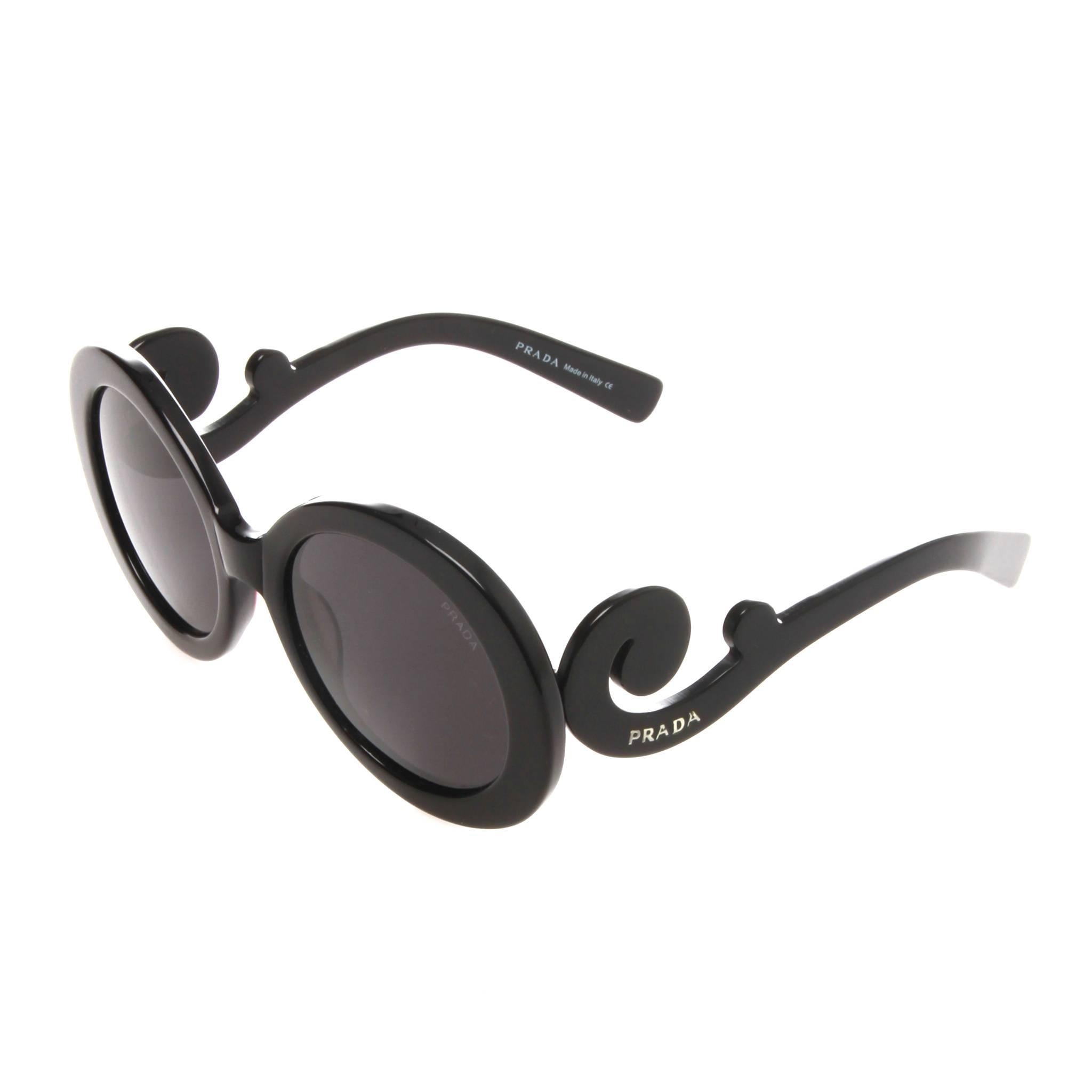 Black acetate Prada Baroque oversize round sunglasses with grey gradient lenses and baroque details at temples featuring silver-tone logo accent. Includes case.
