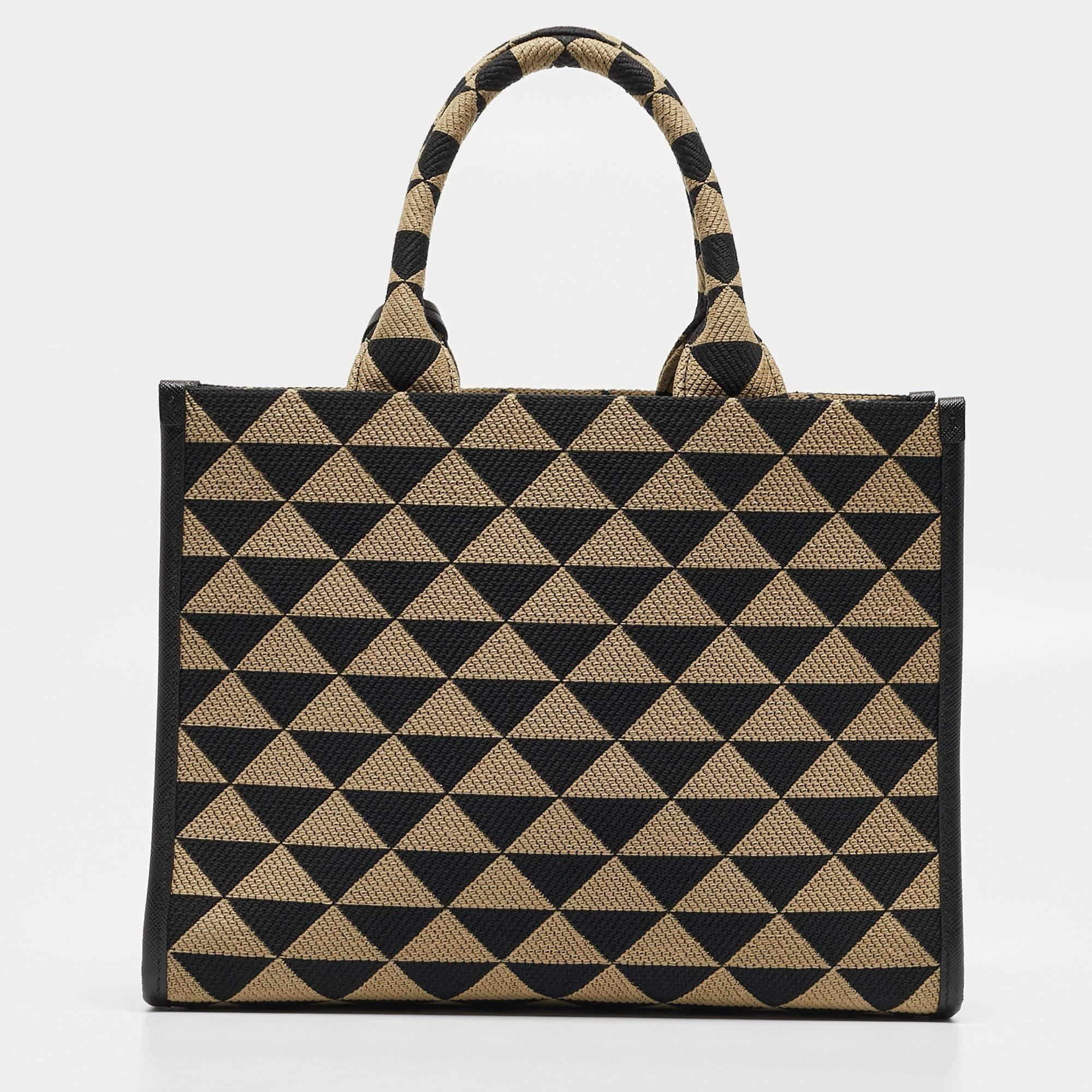 The Prada Symbole Tote is an exquisite blend of sophistication and functionality. Crafted with precision, its beige and black jacquard exterior features the iconic Symbole motifs, exuding timeless elegance. With a compact size, it seamlessly
