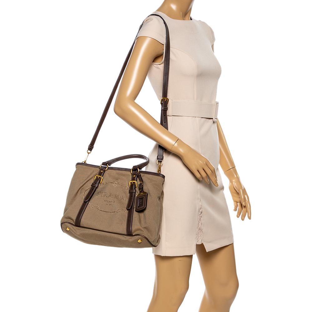 Look fabulous and stylish by adorning this tote from the house of Prada. Made from Canapa canvas and accented with brown leather trims, the bag comes with dual straps, a top zip closure, and a spaciously lined nylon interior that can accommodate