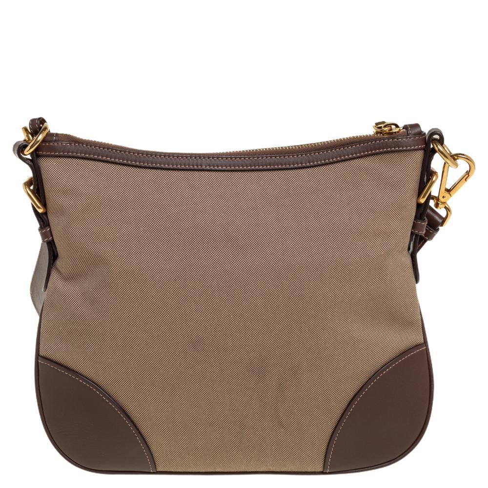 Flaunt this fantastic beige and brown crossbody bag by Prada and gift yourself a sophisticated look. This bag has an inner lining of canvas and leather and is the ideal solution for keeping your daily essentials safe. Carry this Prada classic to