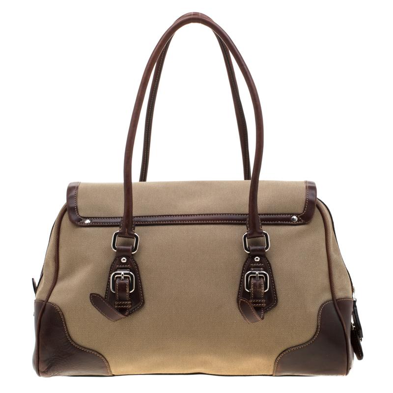 With a classic Prada style that cannot be missed, this satchel bag is smart and elegant for both professional and regular wear. Crafted in beige canvas and accented with brown leather details, this bag features brand name embroidery along with a