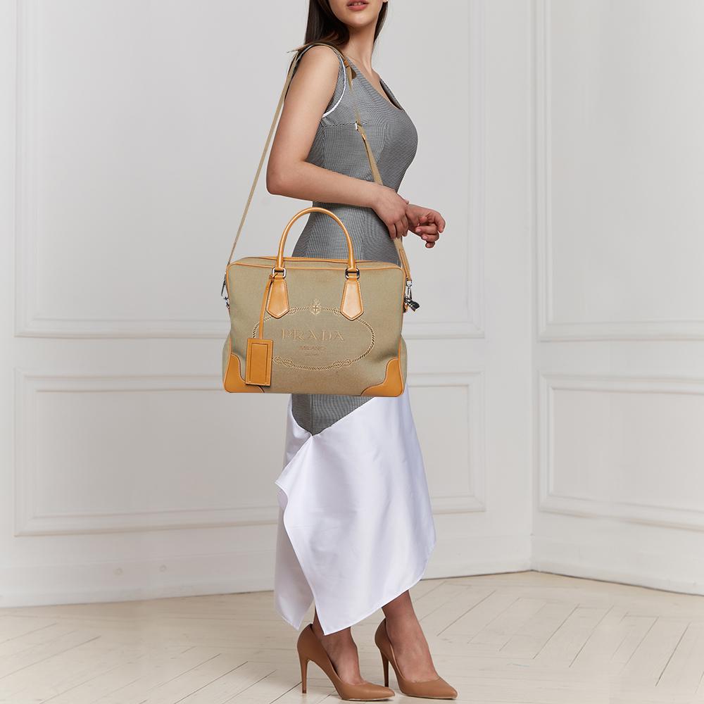 The Prada bag epitomizes elegance and sophistication. Crafted with precision, it features a captivating interplay of beige jacquard fabric adorned with the iconic Prada logo and supple brown leather accents. This timeless accessory exudes luxury and
