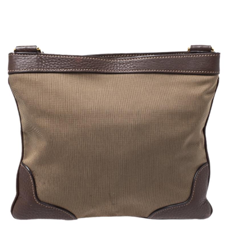 This beige/brown crossbody bag by Prada is crafted in jacquard fabric with leather trim detailing. It also features gold-tone hardware and the brand logo on the front. The top zipper opens to a fabric-lined interior and the bag is very much ideal