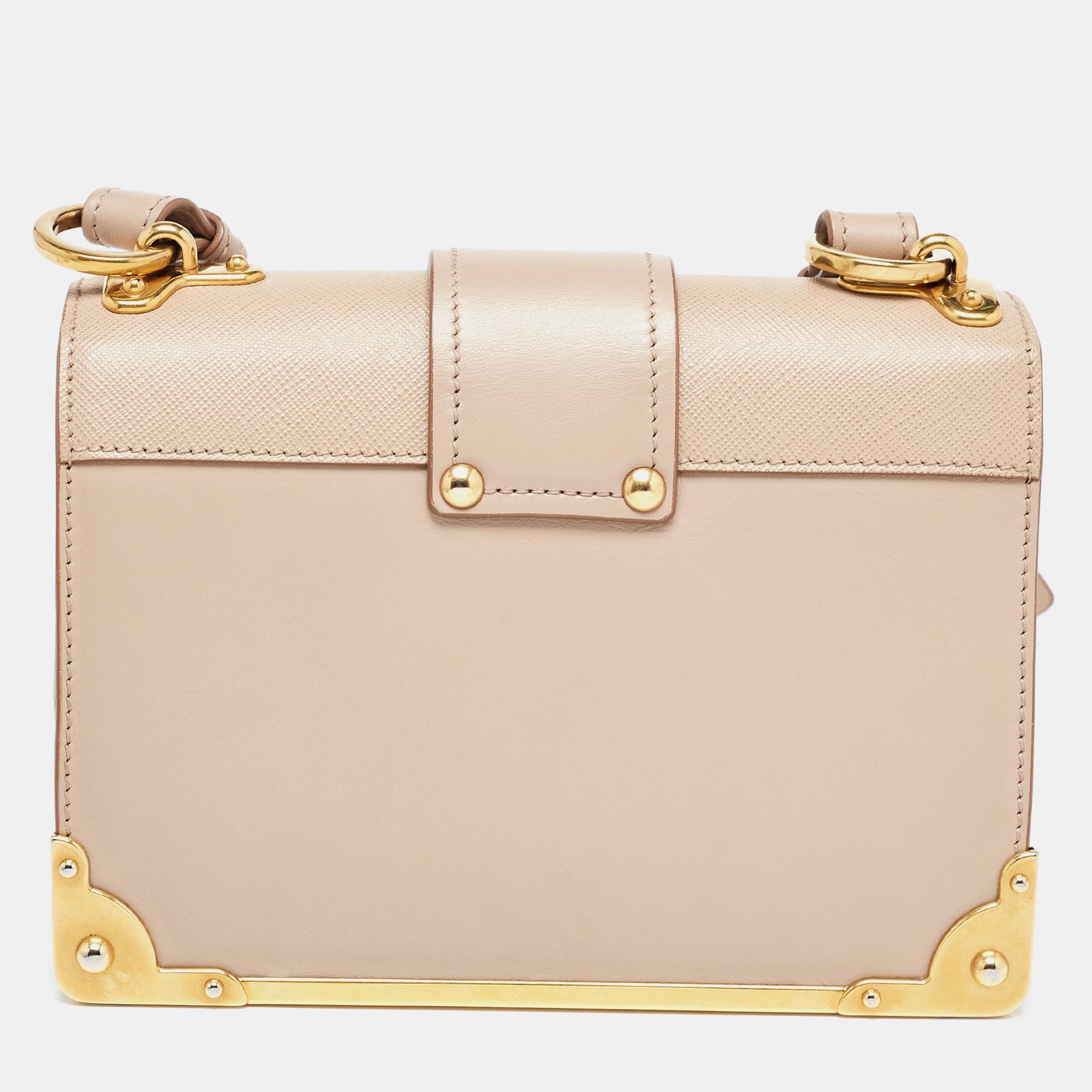 The Prada Cahier shoulder bag is an exquisite accessory, crafted from Saffiano and calf leather. Its structured silhouette features a distinctive metal logo embellishment, a flap closure, and a shoulder strap. This iconic design seamlessly blends