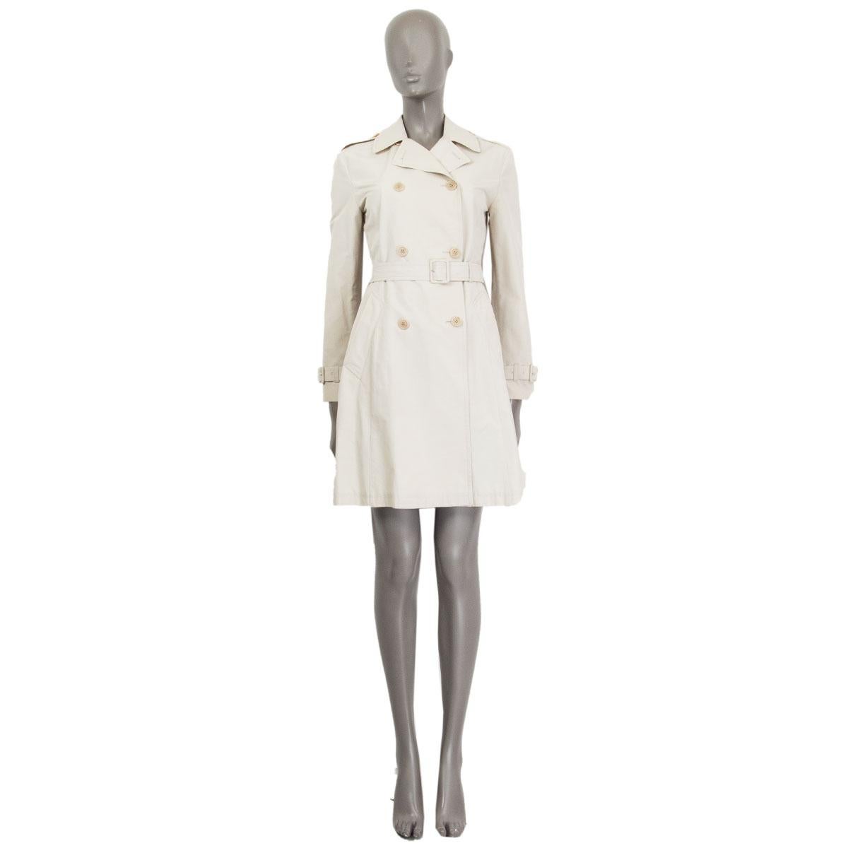 authentic Prada double-breasted belted trench coat in sand cotton (55%) and polyester (45%) with epaulettes on the shoulders and at the sleeves-hem. Opens with four buttons at the front and has slit pockets. Unlined. Has been worn and is in