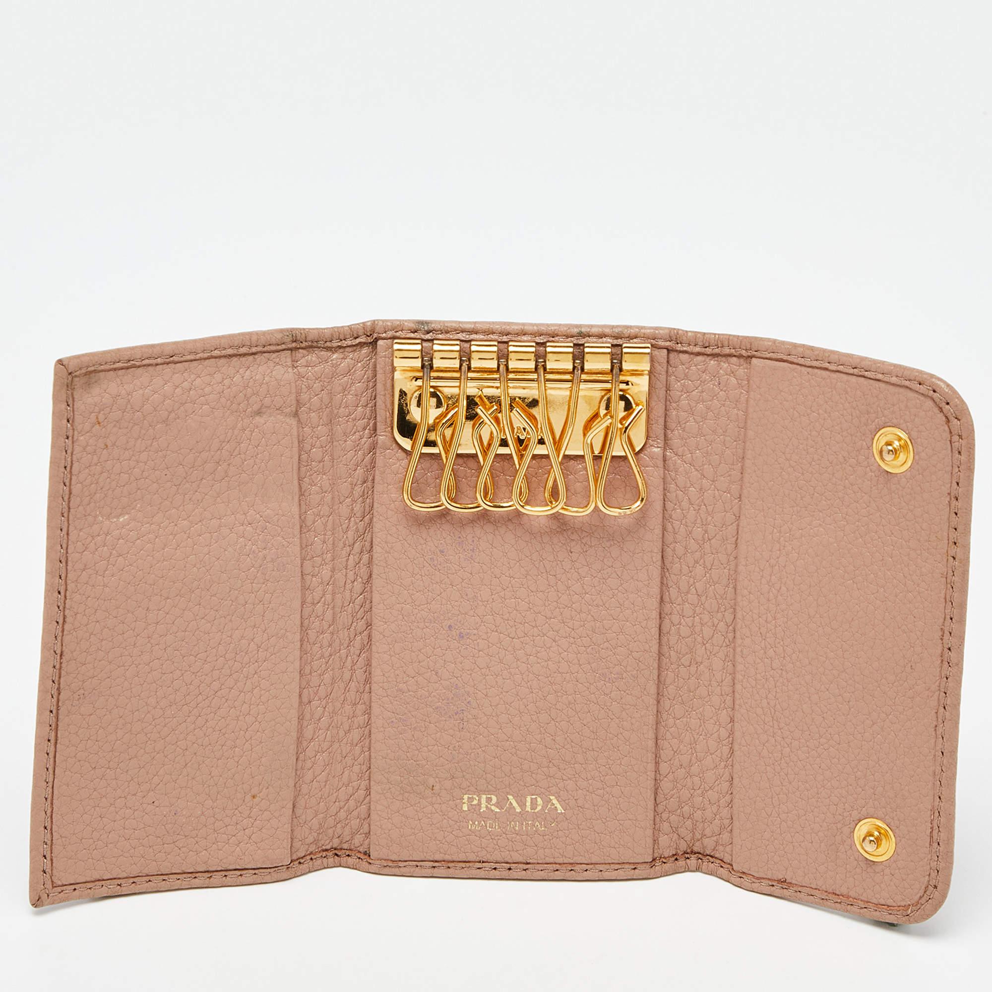 Keep your keys safe and organized with this Prada key holder case. Made from leather, its beige exterior gets a luxe update with the logo on the front.
