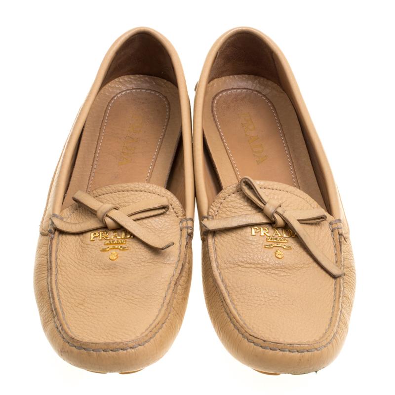 If you're in want of a pair of snug and trendy shoes, this Prada creation is the answer. Crafted from beige leather and designed into a lovely shape, this pair of loafers brings a blend of luxury and comfort. They feature bows on the uppers and
