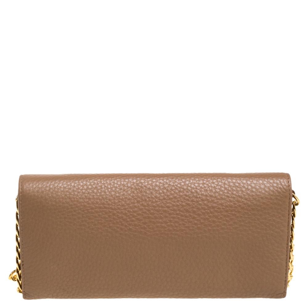 Designed to perfection and crafted from smooth leather, this wallet on chain can be your go-to accessory. Bringing elegance and class to your style, this classic beige-hued wallet from Prada is stylish and convenient. It is finished with a