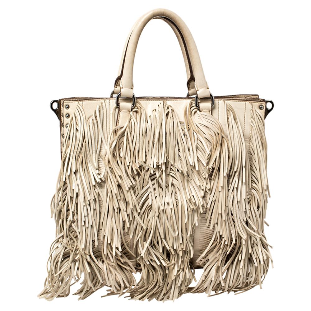 This Prada handbag is an example of the brand's fine designs that are skilfully crafted to project a classic charm. The tote is made of leather and enhanced with fringes, two top handles, a shoulder strap, and a spacious nylon interior.

Includes: