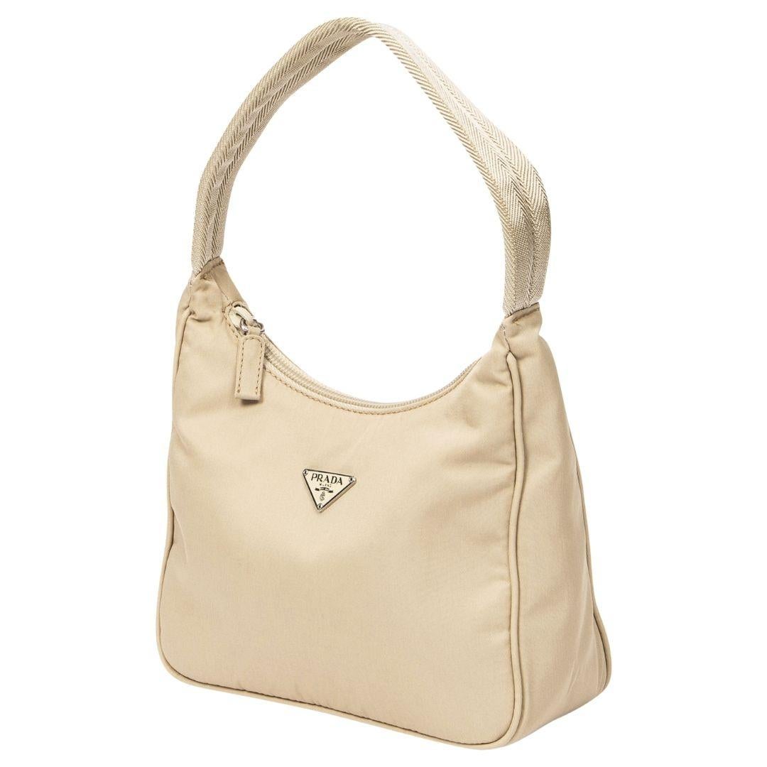 The perfect timeless Prada made from the original beige pocone nylon hobo, silver hardware and zipper closure. It opens to a logo jacquard interior, perfect for everyday essentials.

SPECIFICS
Length: 7.9
Width: 3.2
Height: 7.1
Strap drop: 6
Comes