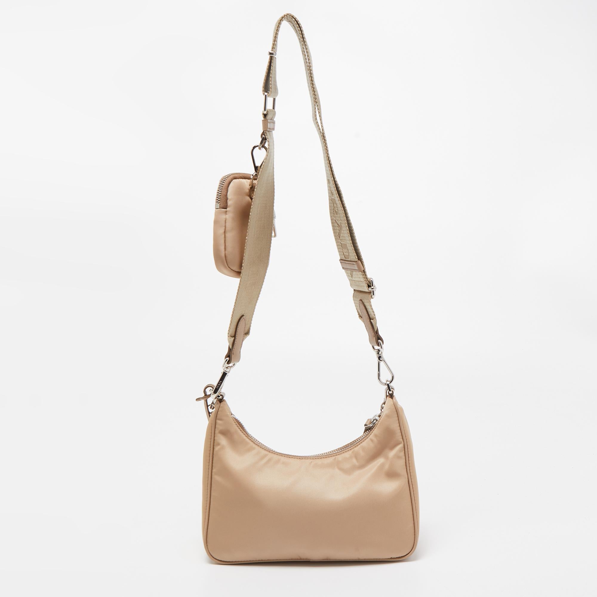 The petite silhouette and classic elements made the Prada Re-Edition 2005 bag an instant hit among fashionistas. Inspired by the classic mini hobo bag, this beige creation comes made from nylon and features a single handle at the top. The perfectly