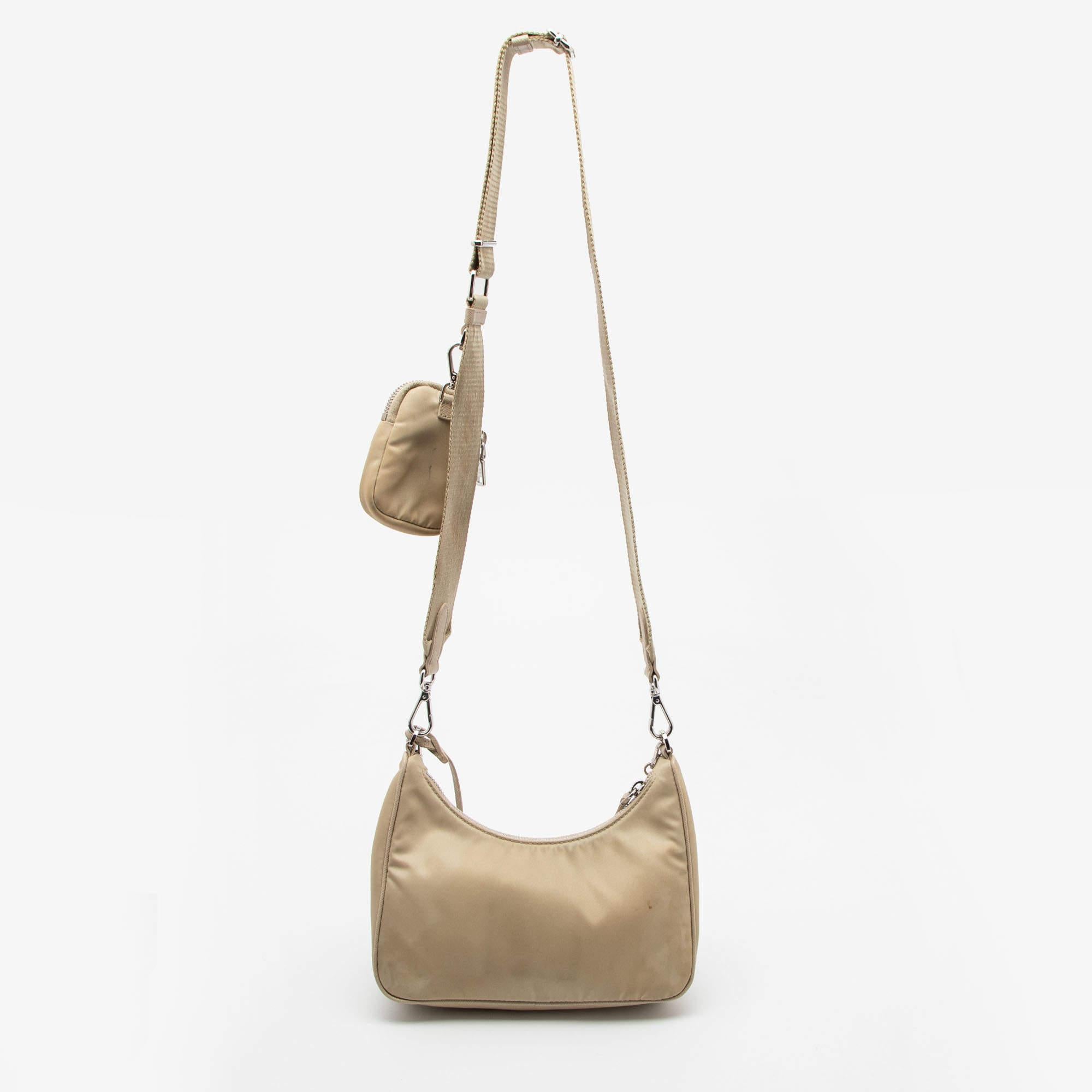 The petite silhouette and classic elements made the Prada Re-Edition 2005 bag an instant hit among fashionistas. Inspired by the classic mini hobo bag, this beige creation comes made from nylon and features a pouch attached to the single handle at