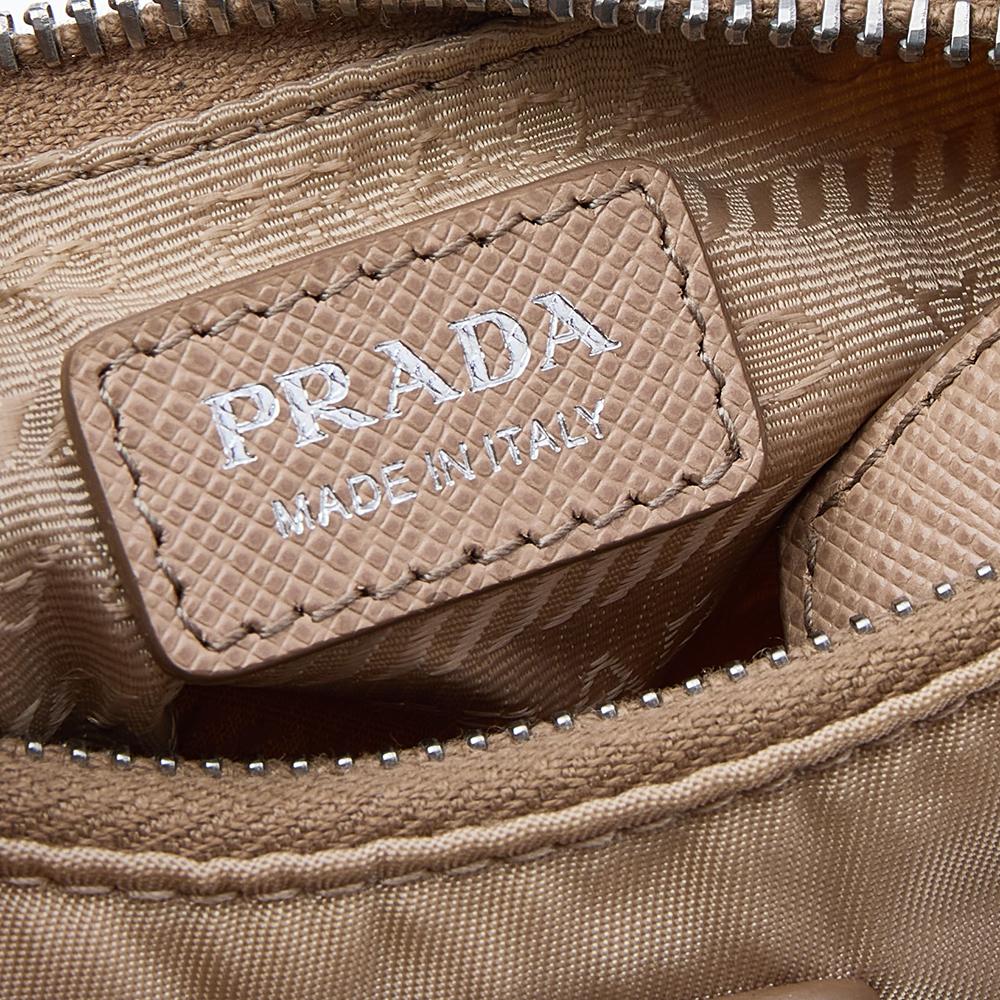 The bag that has caught the instant fancy of celebrities, bloggers, and everyone fashionable, Re-Edition 2005 from Prada is one of the 'IT' bags of the season. Designed in a petite silhouette from nylon, the bag has a beige hue and features classic