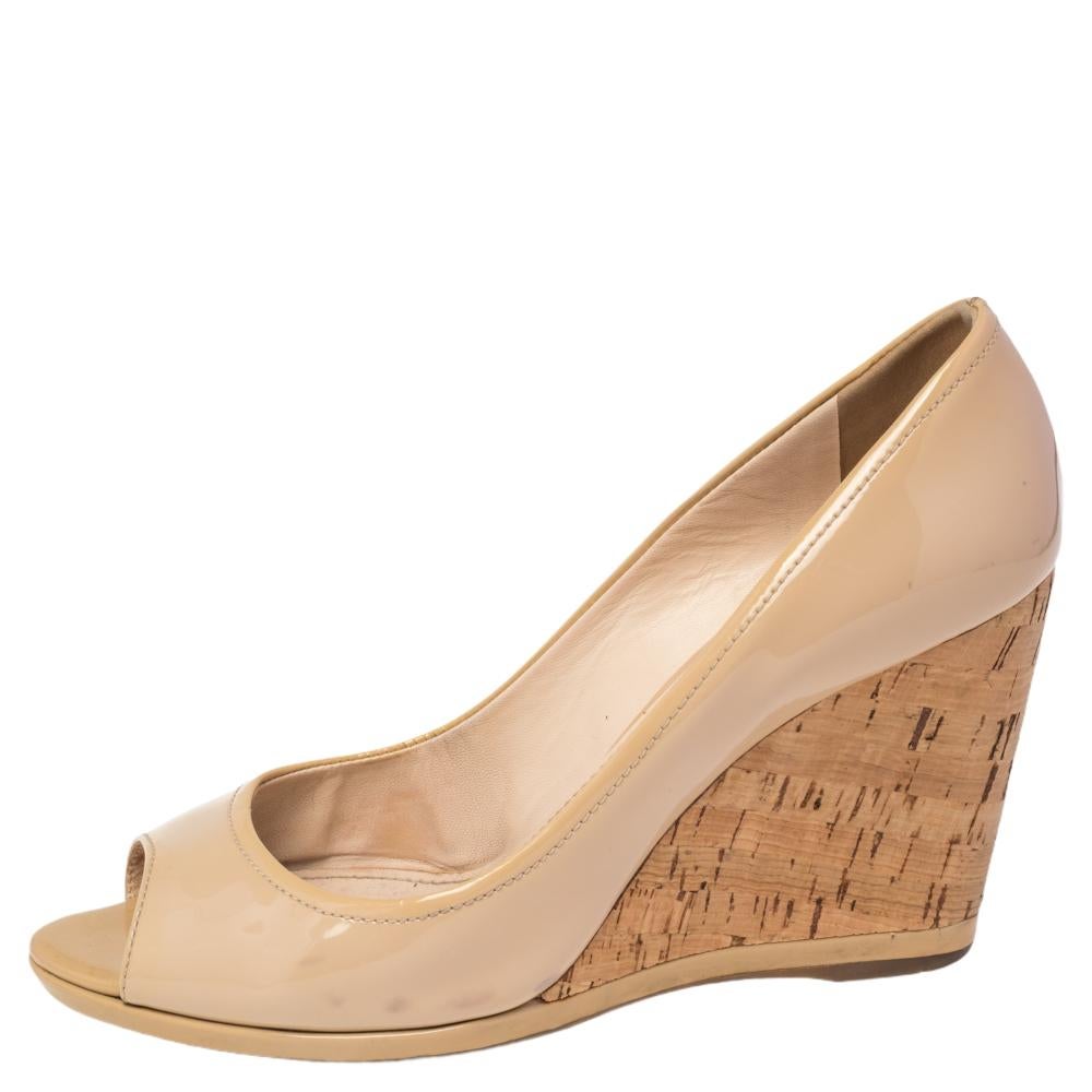 Easily go from day to night in these comfortable yet stylish patent leather peep toe cork wedges by Prada. These slip-on style wedges have glossy patent leather uppers that feature rounded peep toes and cork with patent leather-lined 9.5 cm wedge