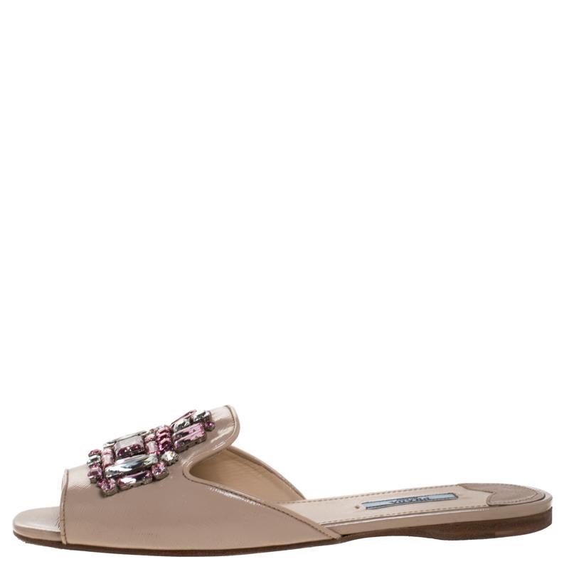 These flats from Prada are feminine and super comfortable to wear all day long. They are made from beige patent Saffiano leather and designed as open-toes. The main attraction of the slides is the crystals embellished on the uppers. They are