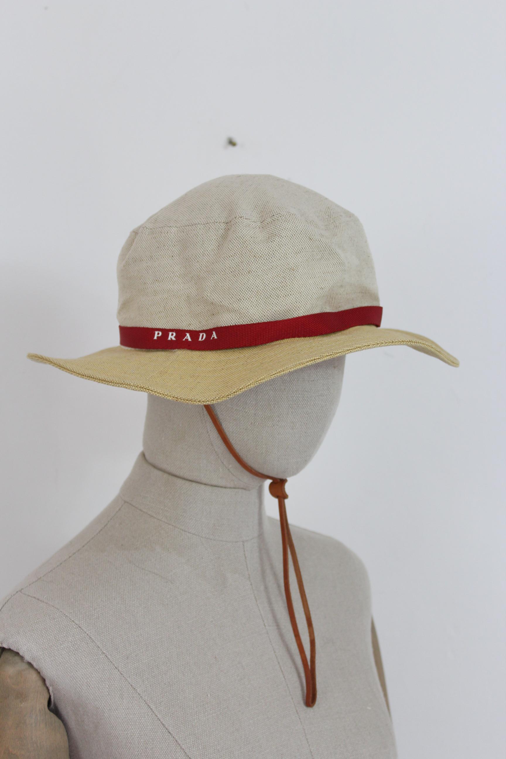 Prada vintage 90s unisex hat. Cowboy model, adjustable leather neck strap. Beige color and red details, 52% linen 48% cotton. Made in Italy. Excellent vintage conditions.

Size: L.

Diameter: 18 cm