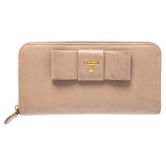 Portafoglio con zip e fiocco in pelle saffiano beige di Prada