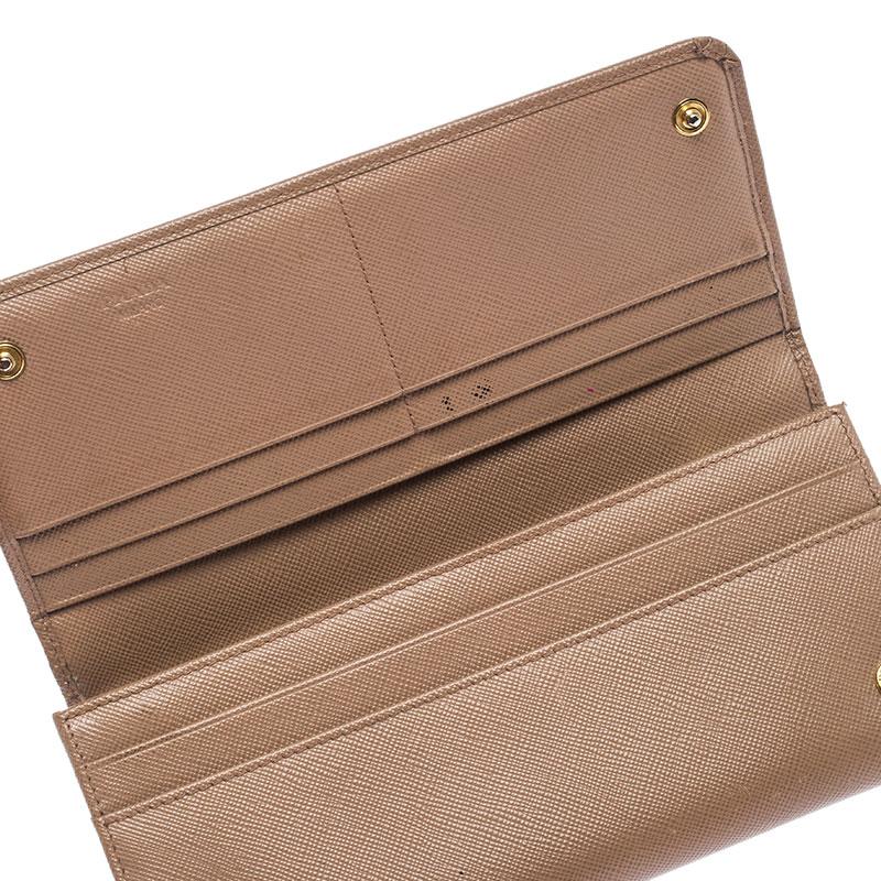 This functional design from Prada will make your daily life easier. Crafted from Saffiano leather, this beige wallet has the brand logo on the front and fabric lining on the inside. It is sleek and comes with gold-tone hardware and enough slots for
