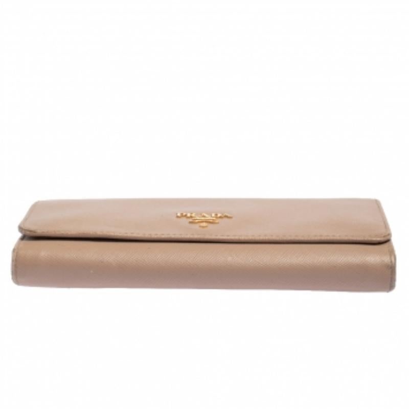 Functional and stylish, Prada's collections capture the effortless, nonchalant finesse of the modern woman. Crafted from Saffiano Lux leather in a beige hue, this chic wallet features a compartmentalized interior with a logo-accented flap. The