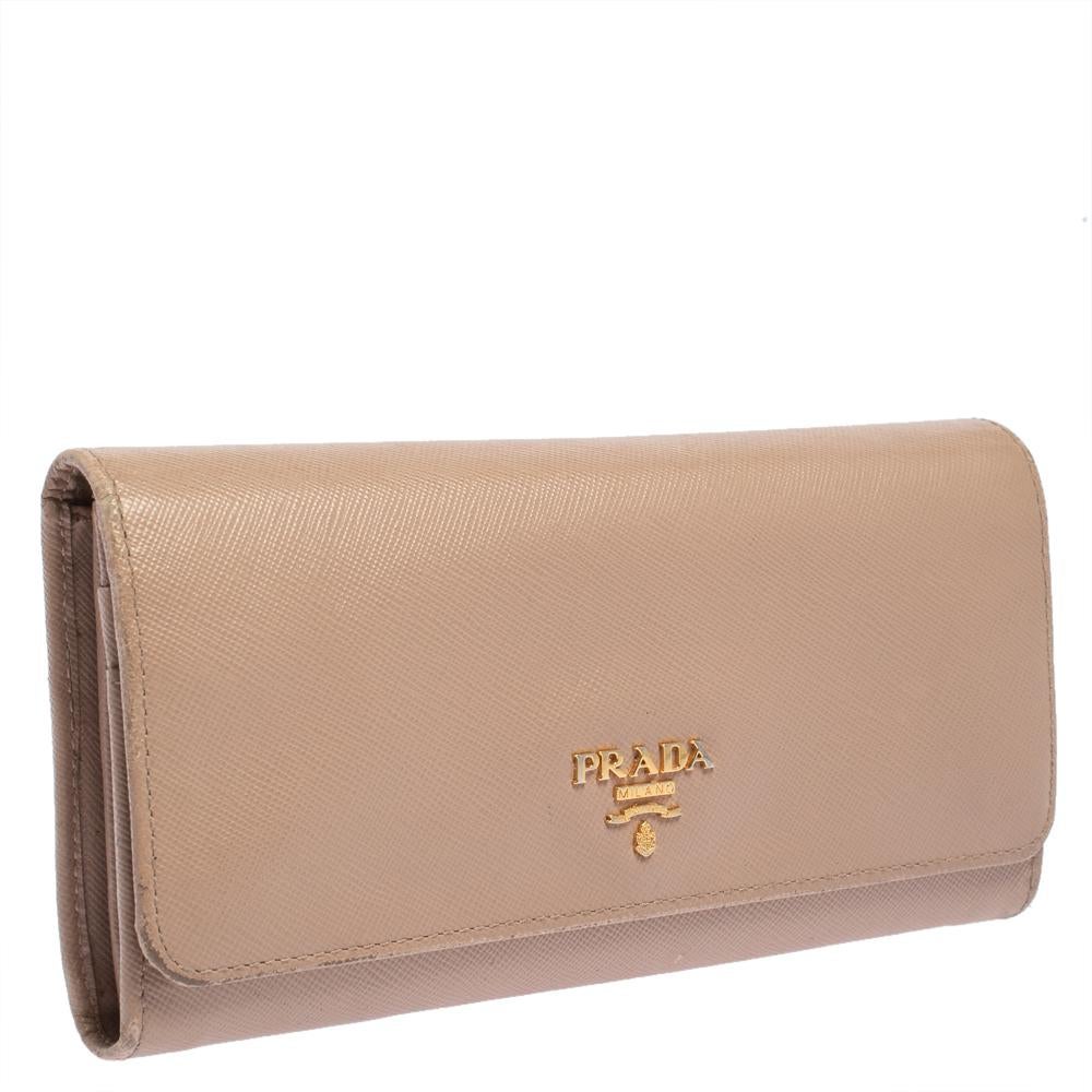 Functional and stylish, Prada's collections capture the effortless, nonchalant finesse of the modern woman. Crafted from Saffiano Lux leather in a beige hue, this chic wallet features a compartmentalized interior with a logo-accented flap. The
