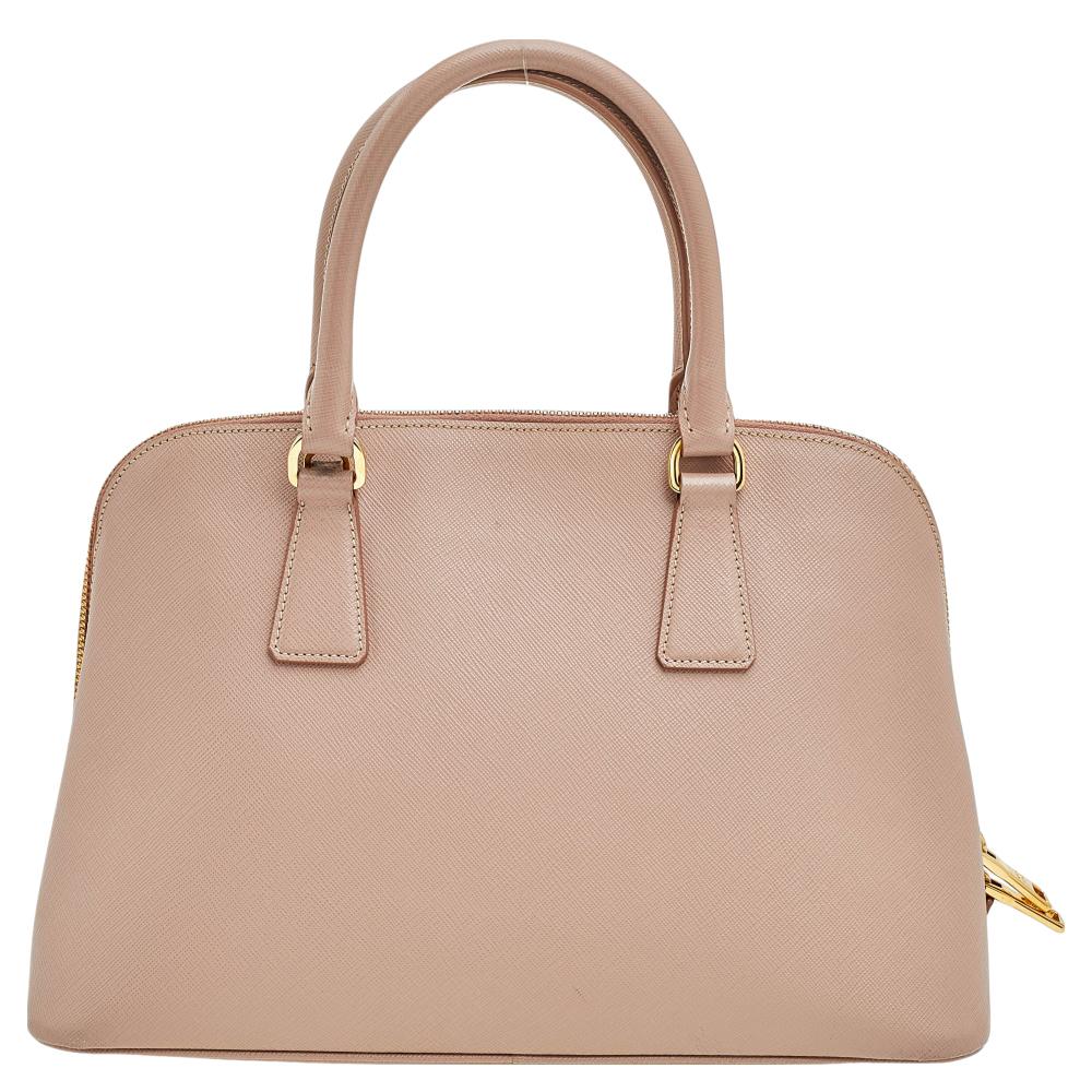 This stunning Promenade tote is high on appeal and style. Dazzling in a classy beige shade, the bag is crafted from Saffiano leather and features two rolled handles. The zip closure leads way to a nylon interior with enough space for your essentials