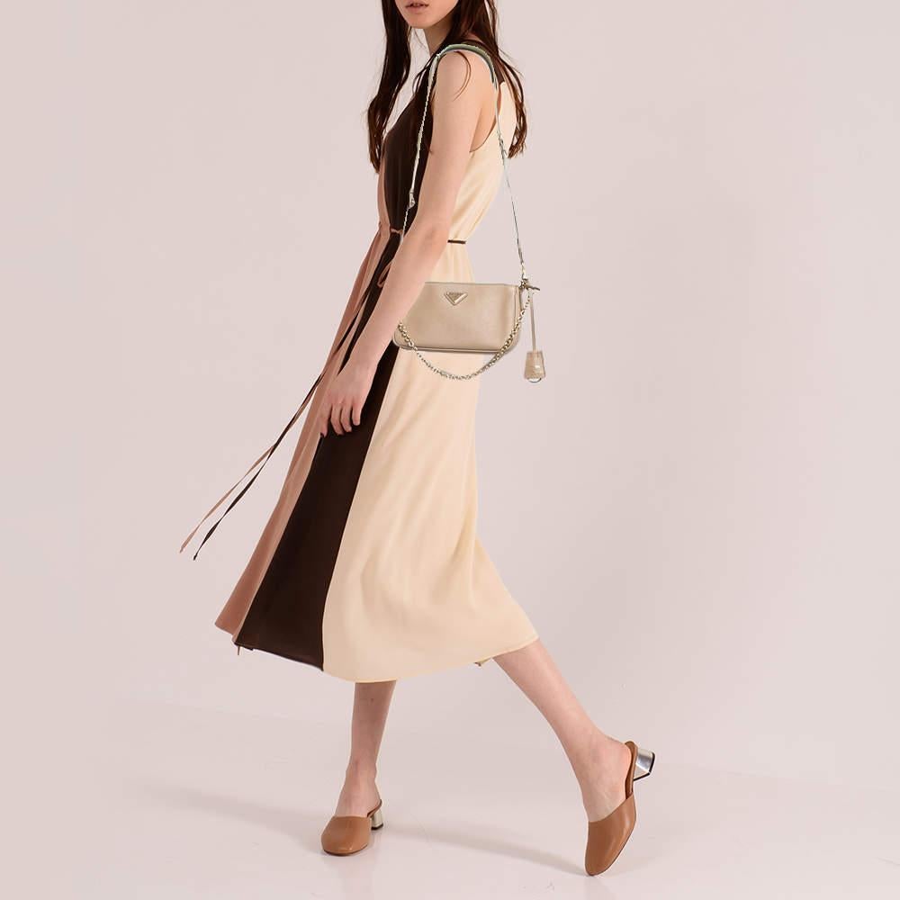 The petite silhouette and classic elements made the Prada Re Edition 2000 bag an instant hit among fashionistas. Inspired by the classic mini hobo bag this beige creation comes made from saffiano leather and features a shoulder strap. The perfectly