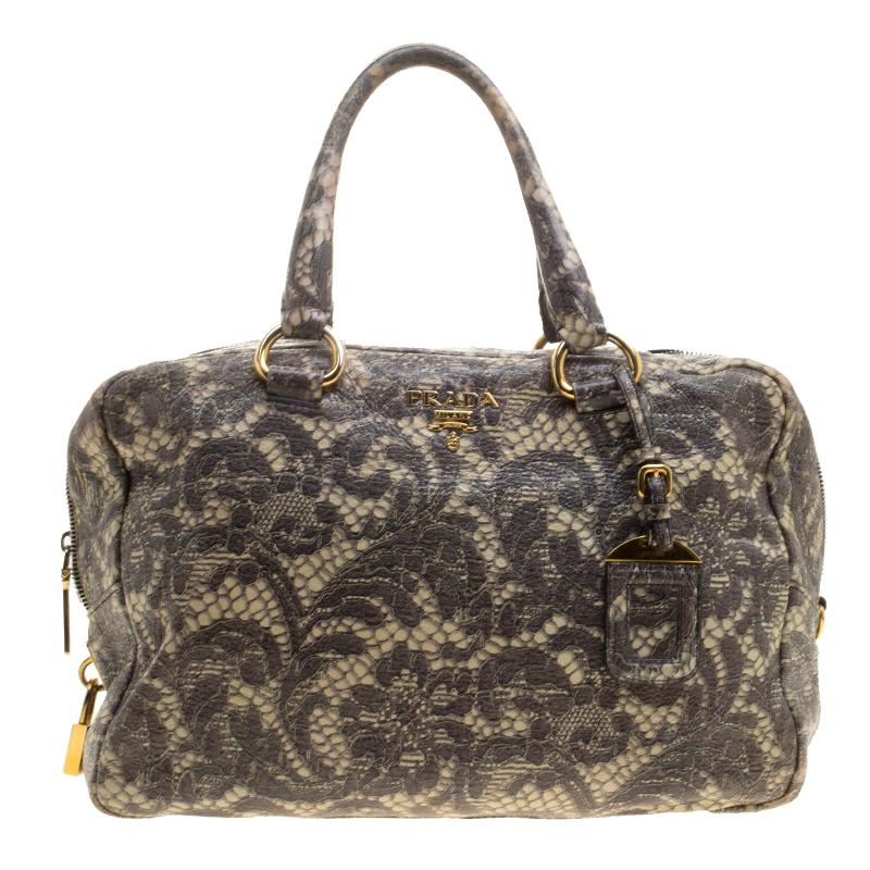 An elegant substitute for your work totes, this Bowling bag from Prada with an intriguing lace print that exudes a feminine vibe makes for a closet essential. Rendered in Cervo leather, the bag features dual top handles with a leather tag and