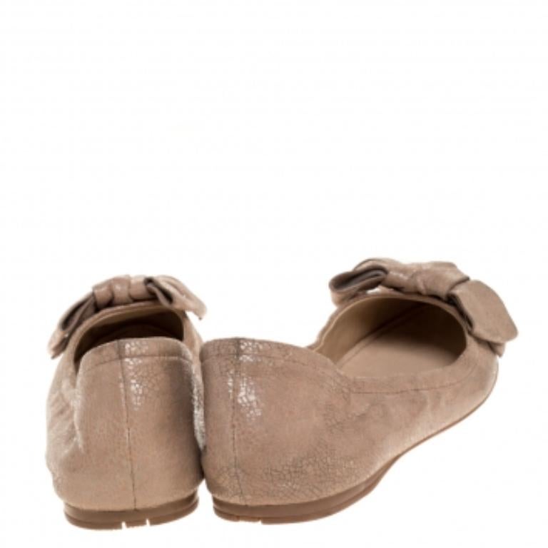 Stay comfortable throughout the day in these beige ballet flats by Prada. This impressive pair of textured leather flats makes a luxe style statement. They feature cute bow details, rubber soles and leather insoles.