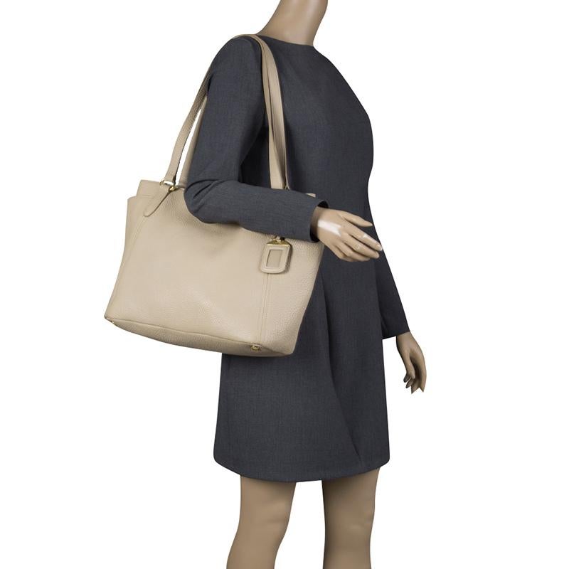 From the sturdy exterior crafted with Vitello Daino leather to the spacious nylon-lined interior, this shopper tote from Prada is a flawless blend of style and practicality. This handy piece features two top handles, a muted beige hue, a leather