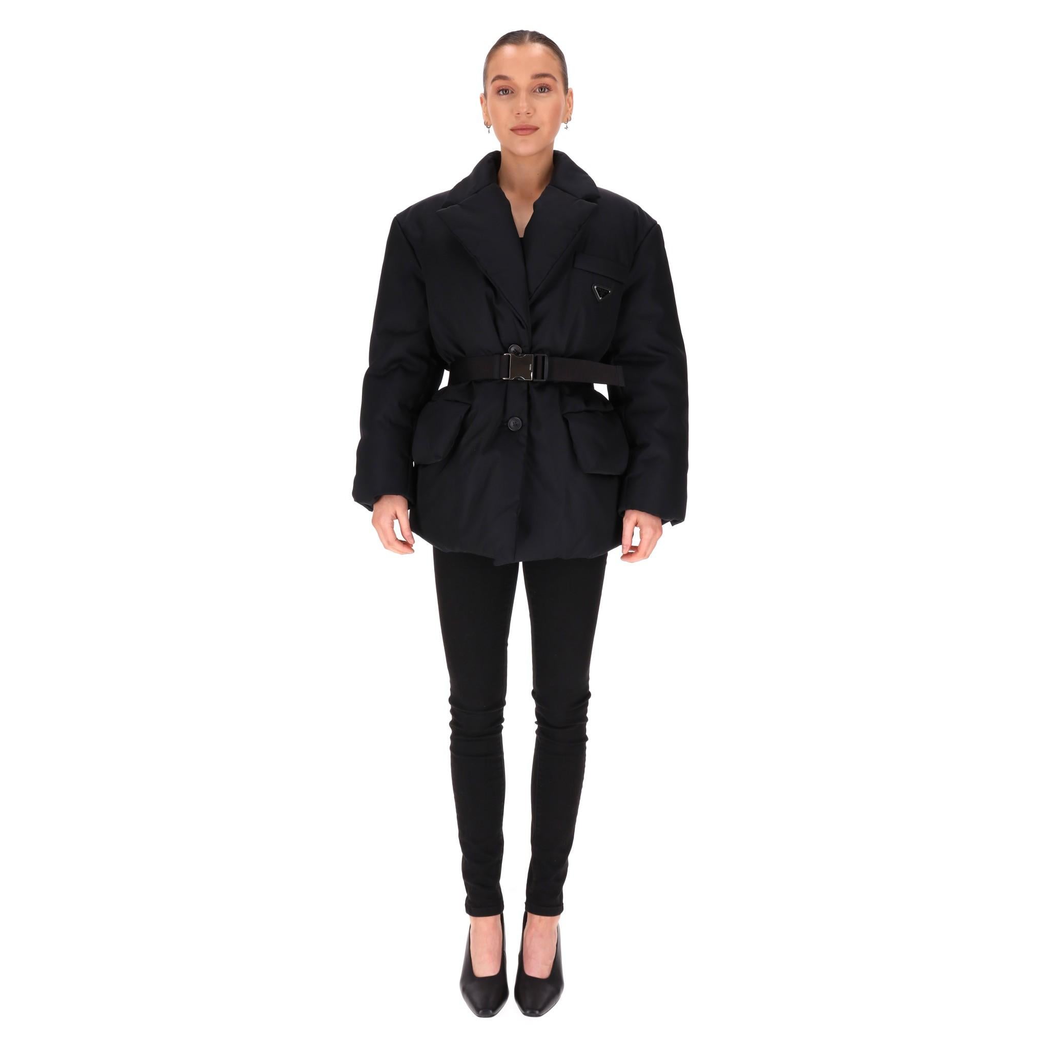 Collezione attuale - Piumino imbottito con cintura di Prada

Giacca nera imbottita in piuma d'oca, con ampi revers, chiusura centrale con bottoni e polsini.

Caratterizzato da una cintura in vita con fibbia in metallo con logo. Il logo a triangolo