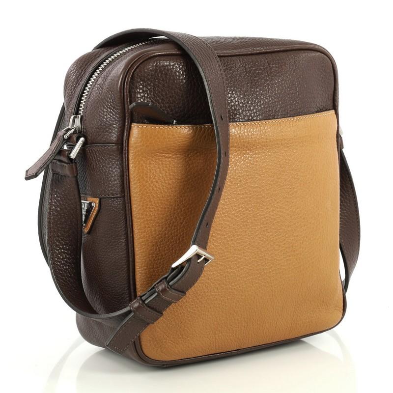 This Prada Bicolor Zip Crossbody Bag Vitello Daino Small, crafted in brown leather, features an adjustable leather strap and silver-tone hardware. Its top zip closure opens to a brown leather interior with side zip pocket.

Condition: Great.