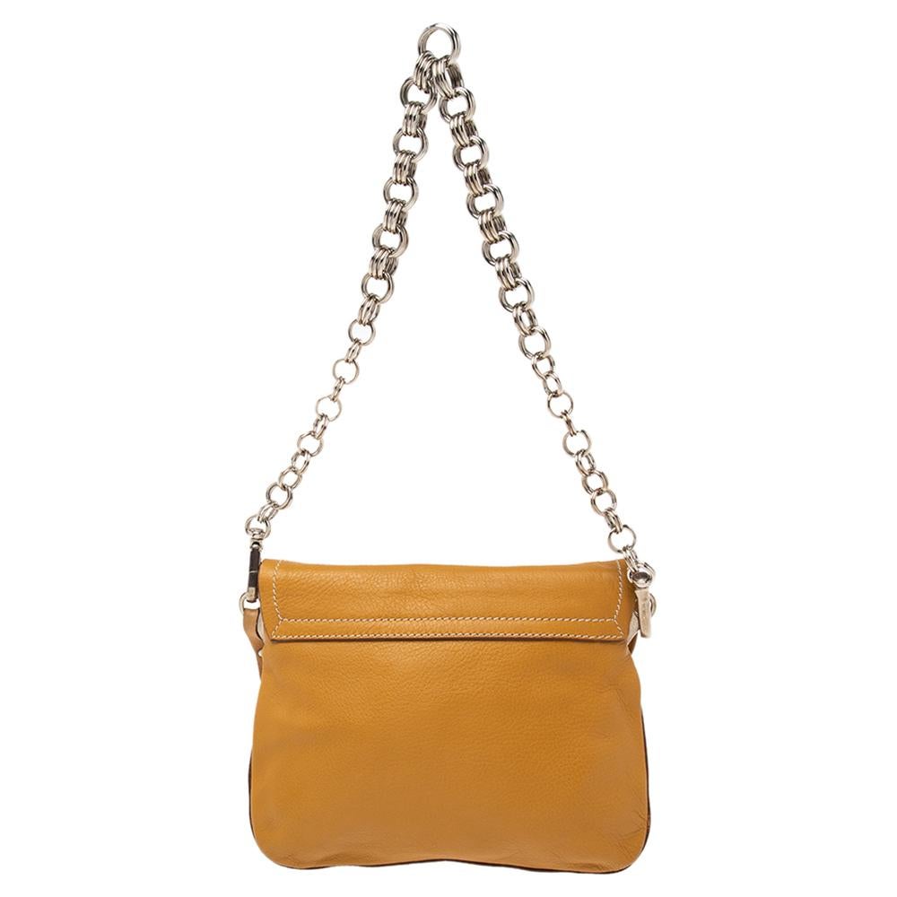 A perfect bag to take for shopping or otherwise, this bag from Prada is crafted from biscotti beige-hued leather. It features a front flap secured with a silver-tone, logo-engraved snap closure, a long chain-link shoulder strap, and a spacious